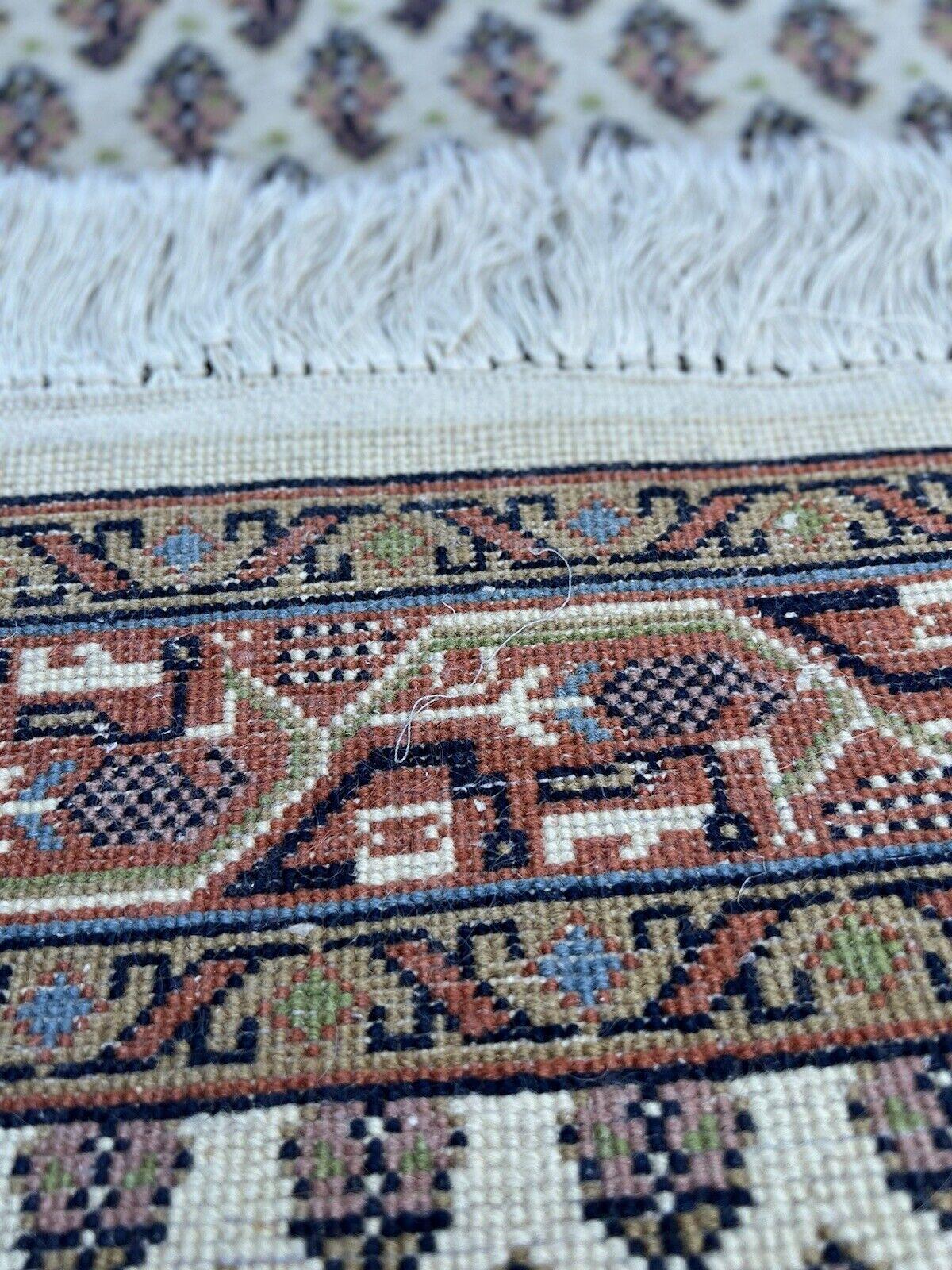 Entdecken Sie den Charme der traditionellen indischen Handwerkskunst mit diesem handgefertigten indischen Seraband-Teppich im Vintage-Stil. Dieser Teppich aus den 1970er Jahren misst 2,3' x 5' (72cm x 155cm) und ist eine reizvolle Ergänzung für