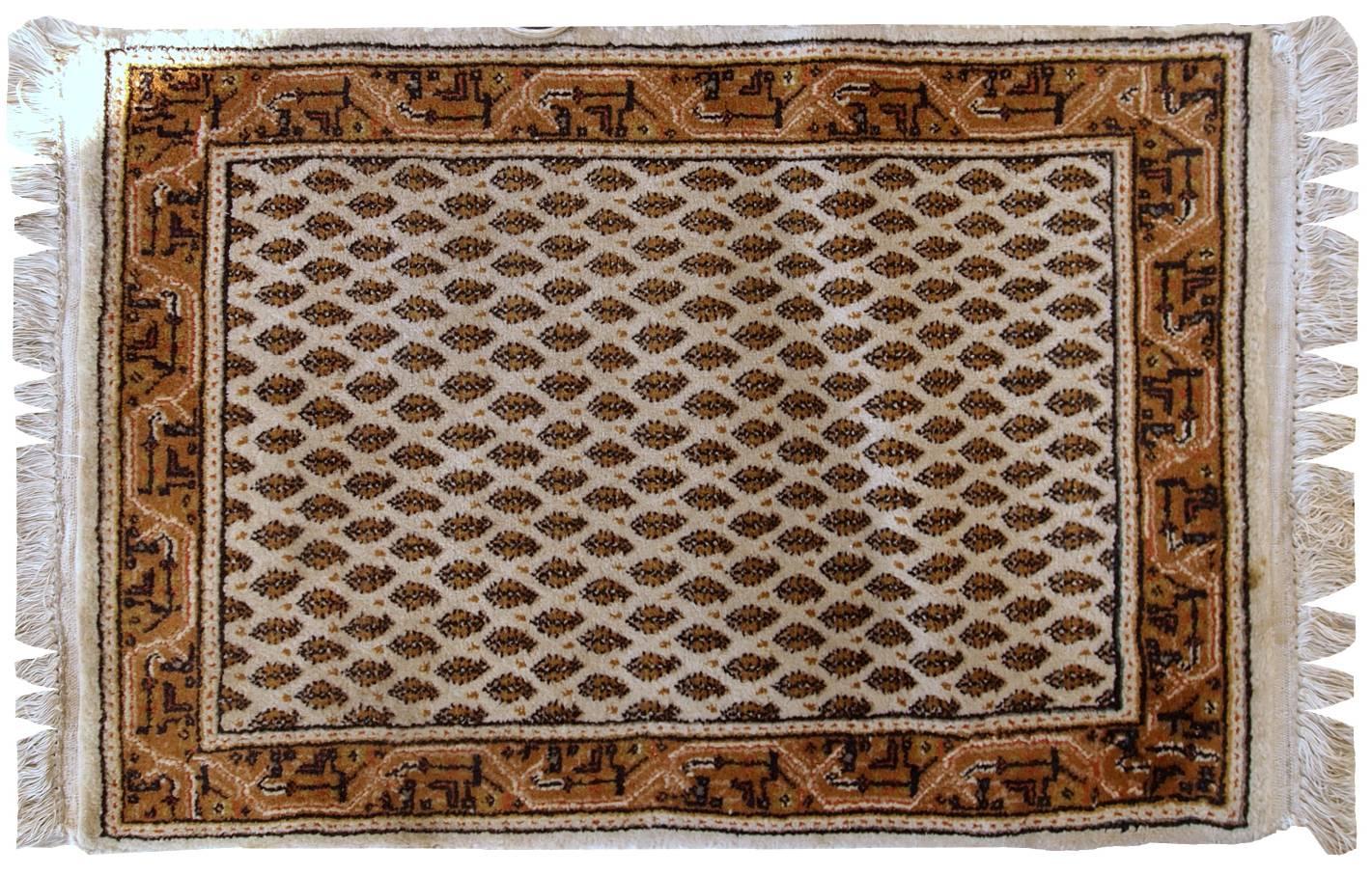 Vintage Indian rug in the style of Persian Seraband. Repeating pattern on the white field, the border is geometric in brown and olive shades. It is in original good condition with full thick pile.
 