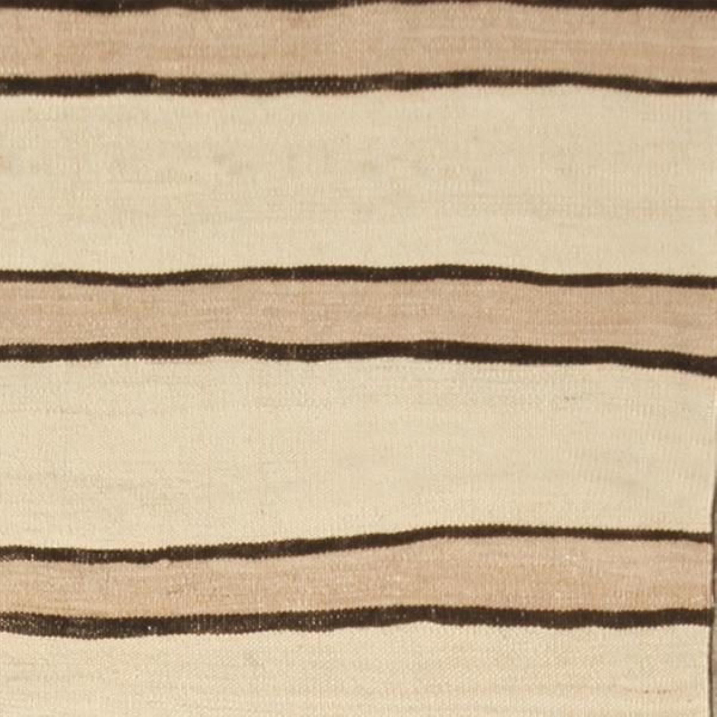 Dieser handgewebte, flachgewebte Wollteppich aus der Türkei (ca. 1950-1960) zeigt ein Stammesdesign aus der Mitte des Jahrhunderts in einer seltenen Farbvariante. Er zeigt klassische Streifenmuster in Gelb- und Weißtönen, die in der vernünftigen,