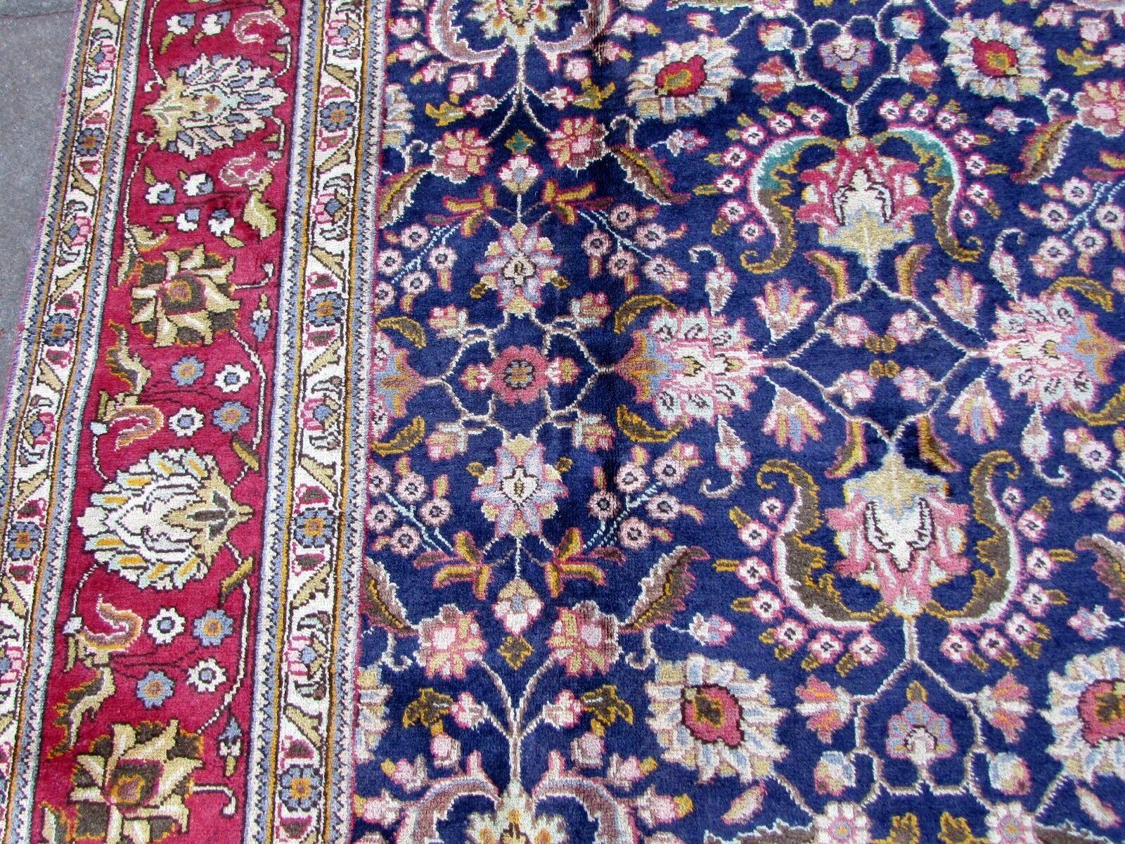 Handmade vintage Mashad rug in traditional floral design and indigo wool. The rug is from the end of 20th century in original good condition.

-condition: original good,

-circa 1970s,

-size: 9.5' x 12.7' (291cm x 389cm),

-material: