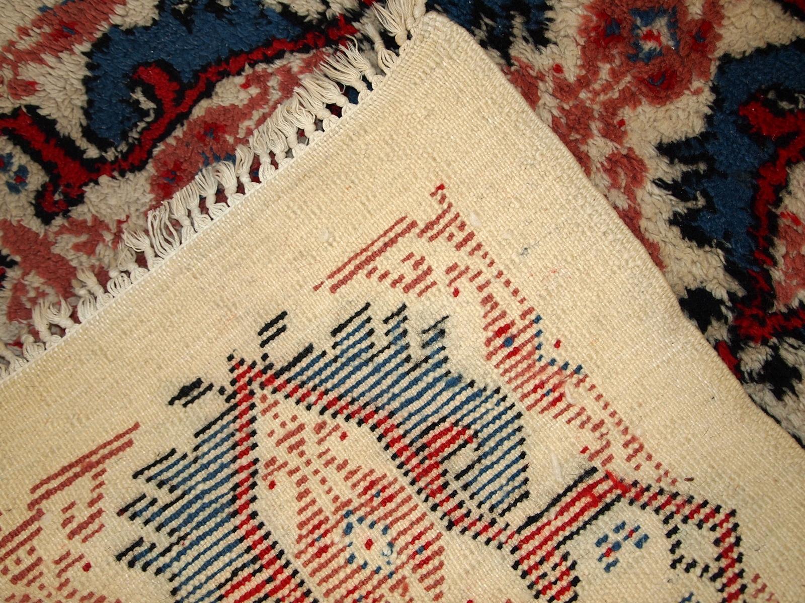 Handmade vintage Moroccan Berber rug in white, blue and red wool. The rug is in original good condition, from the end of 20th century.

- Condition: original good,

- circa 1970s,

- Size: 2.6' x 5.4' (80cm x 165cm),

- Material: wool,

-