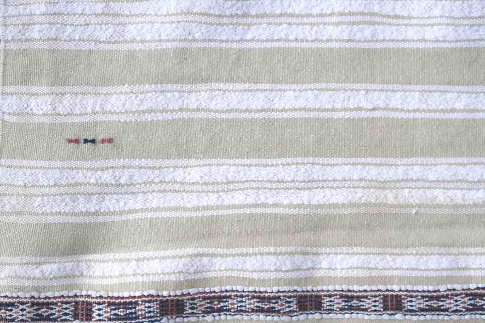 Handmade vintage Moroccan woolen kilim in white color with the stripes. This flatweave is from the middle of 20th century in original good condition.

-condition: original good,

-circa: 1950s,

-size: 3.7' x 5.7' (113cm x