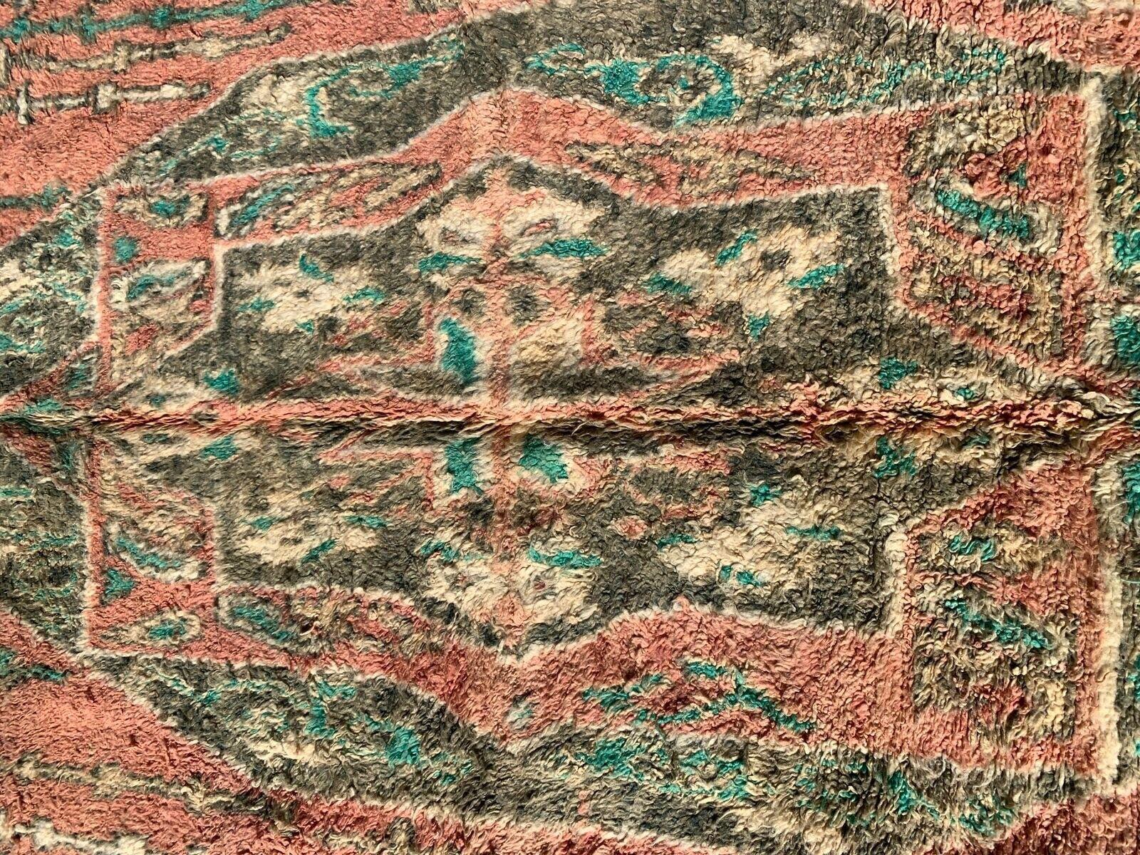 Dieser handgefertigte marokkanische Berberteppich im Vintage-Stil aus den 1990er Jahren ist ein Zeugnis für die anhaltende Anziehungskraft marokkanischer Kunstfertigkeit. Mit den Maßen 5,5' x 10' weist es eine ausgeprägte lachsfarbene Farbpalette