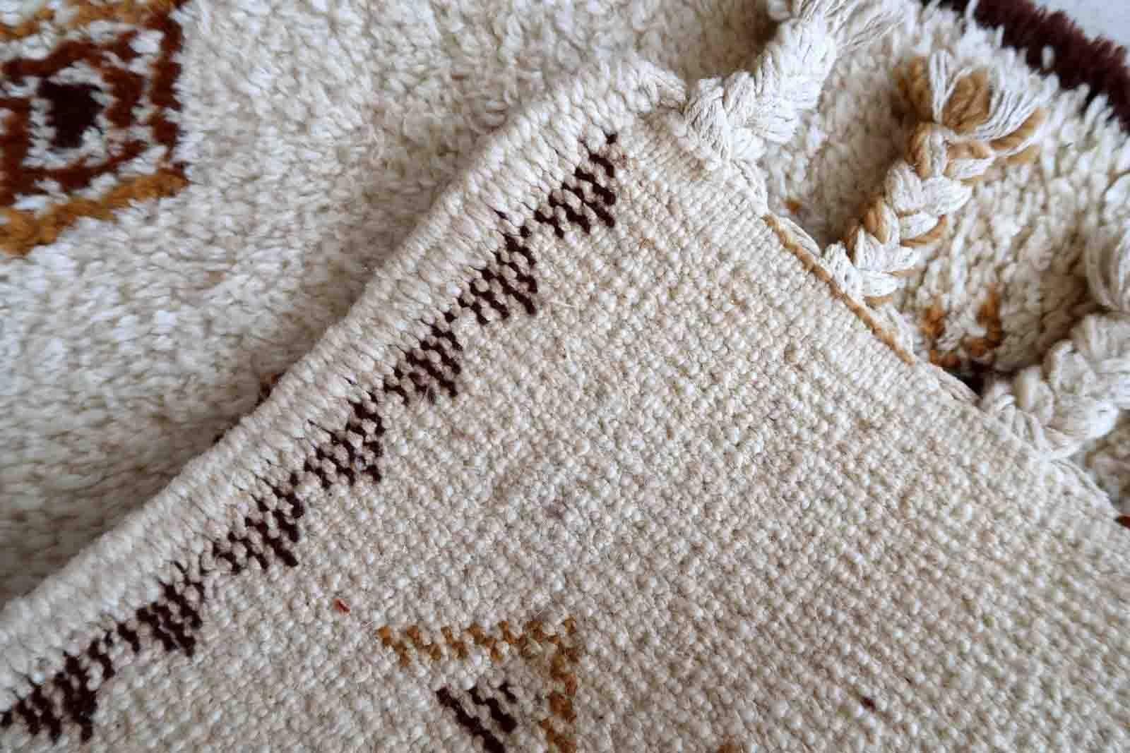 Handmade vintage Moroccan Berber woolen rug in white and brown colors. The rug is from the end of 20th century in original good condition.

-condition: original good,

-circa: 1970s,

-size: 2.4' x 4.4' (74cm x 136cm),

-material: