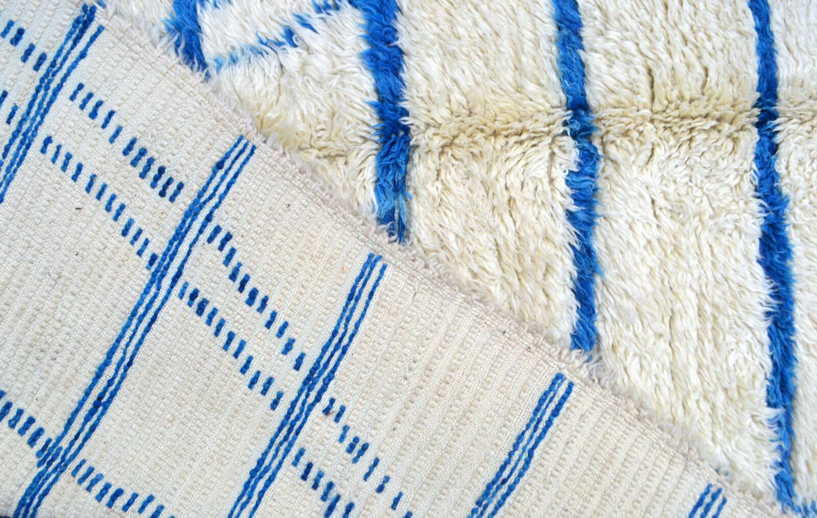 Handmade vintage Moroccan Berber rug in white and blue wool. The rug is from the end of 20th century in original good condition.

- Condition: Original good,

- circa 1980s

- Size: 5.9' x 9.5' (180cm x 290cm),

- Material: Wool,

-