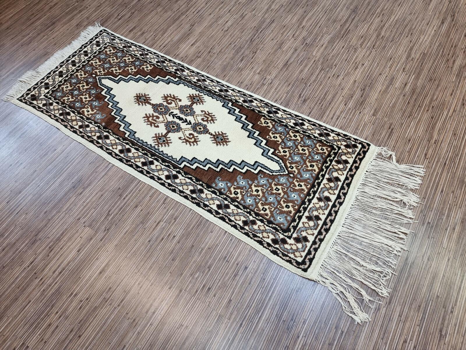 Verwandeln Sie Ihren Raum mit unserem handgefertigten marokkanischen Berberteppich im Vintage-Stil, einem beeindruckenden Stück Kunst und Geschichte. Dieser Teppich wurde in den 1960er Jahren hergestellt und misst 2' x 5.1' oder 62cm x 158cm,