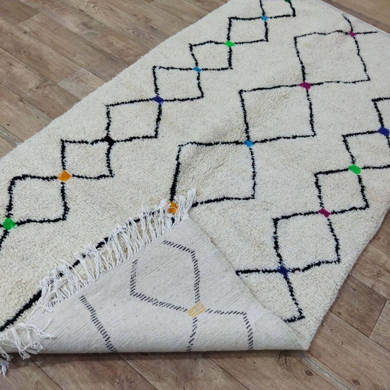 Ce tapis berbère marocain vintage, fabriqué à la main dans les années 1980, est une pièce intemporelle qui célèbre l'art du tissage traditionnel. Fabriqué en laine de haute qualité, il reste en excellent état, n'ayant jamais été utilisé, ce qui