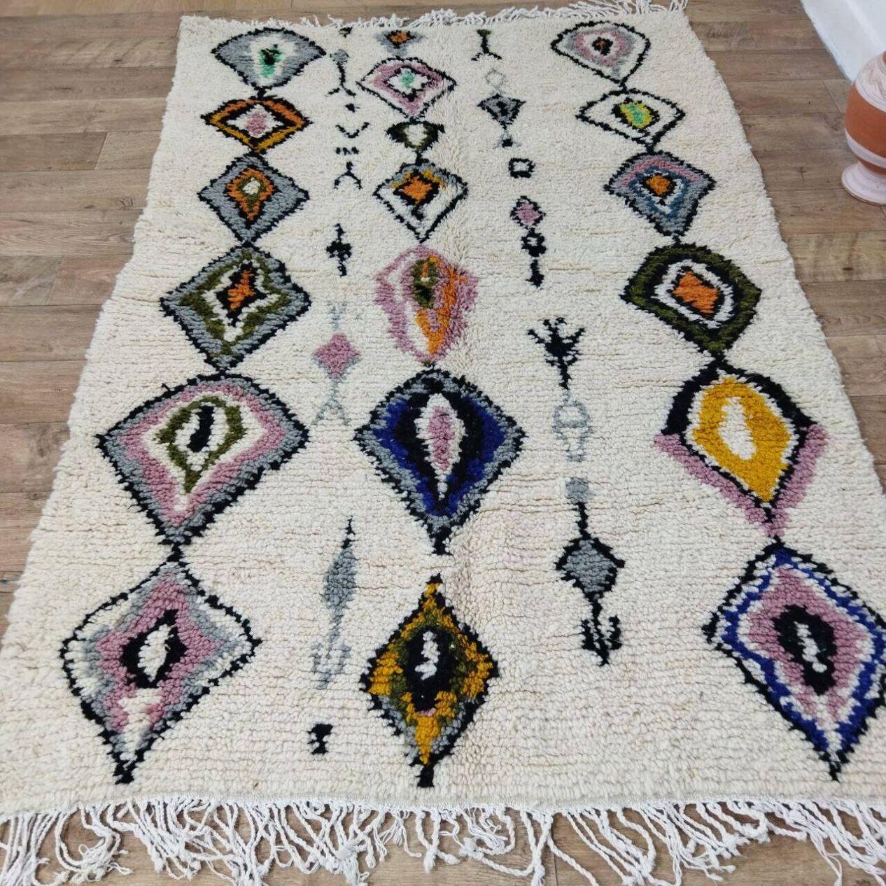 Ce tapis berbère marocain vintage, fabriqué à la main dans les années 1980, reflète l'art et l'héritage culturel du tissage berbère. Fabriqué en laine douce de haute qualité, il est en excellent état et n'a jamais été utilisé, préservant ainsi sa