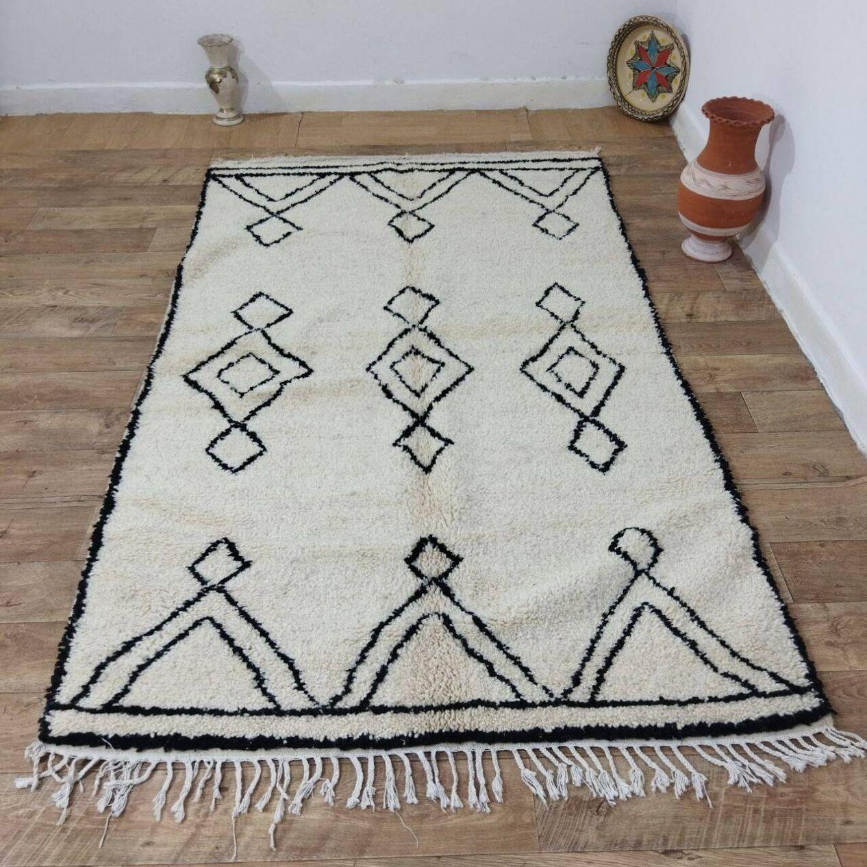 Ce tapis berbère marocain vintage, fabriqué à la main dans les années 1980, illustre la beauté intemporelle du tissage berbère traditionnel. Fabriqué en laine douce de haute qualité, il reste en excellent état, n'ayant jamais été utilisé, préservant