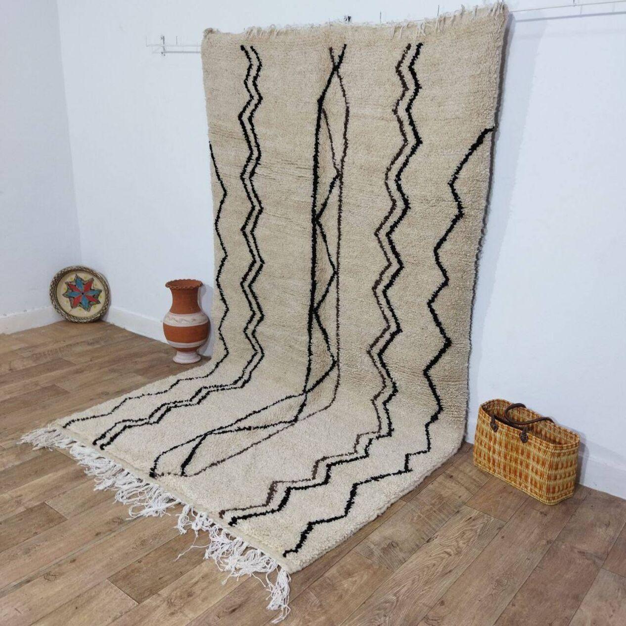 Cet exquis tapis berbère marocain vintage, fabriqué à la main dans les années 1980, incarne magnifiquement la riche tradition et le savoir-faire des tisserands berbères. Fabriqué en laine douce de haute qualité, il présente des motifs géométriques