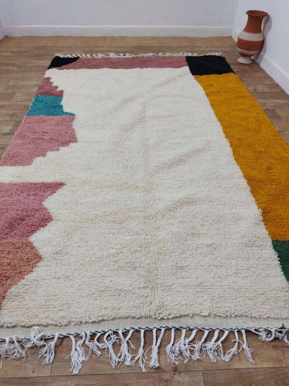 This vintage Moroccan Berber rug from the 1980s is a stunning display of traditional craftsmanship, carefully preserved and never used. Handwoven from high-quality wool, it features an eye-catching geometric design with rich, earthy tones—black,