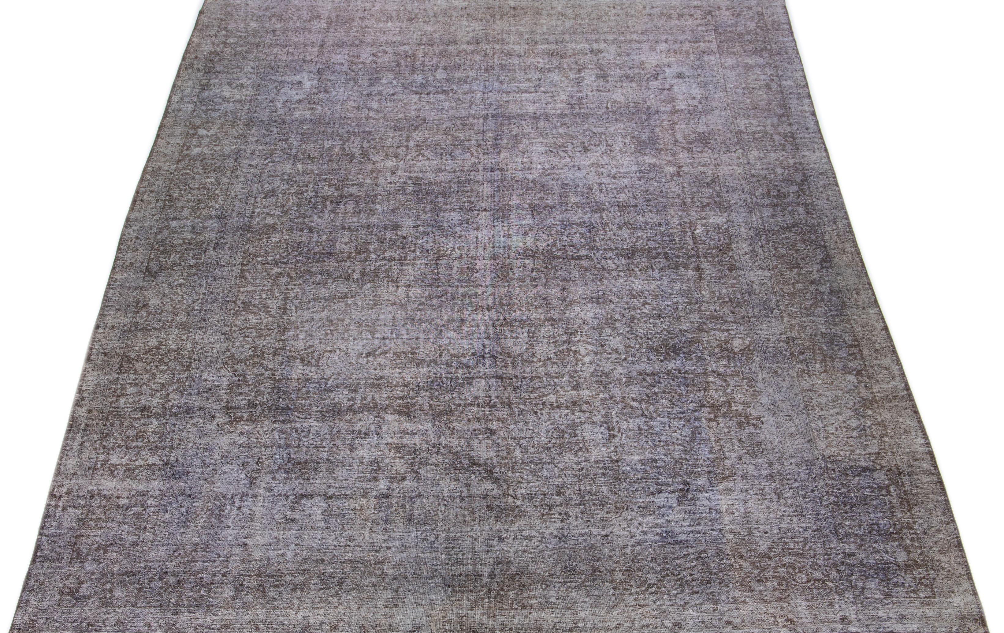 This 1950s Persian rug showcases an elaborate brown floral design that has been purposely distressed and dyed to create a charming rustic effect. The rug's exquisite gray hue lends an air of elegance and refinement to any room it graces.

This rug