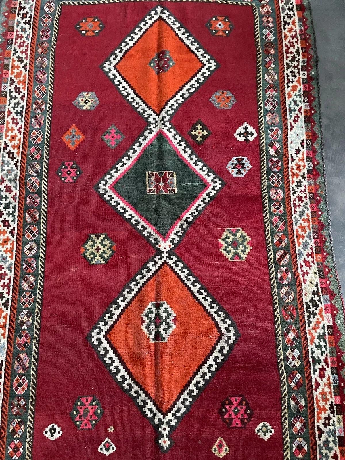 Dieser handgefertigte alte persische Gabbeh-Teppich aus den 1960er Jahren ist ein schönes Beispiel für traditionelle Handwerkskunst und zeitloses Design. Dieser Wollteppich mit den Maßen 107 cm x 204 cm (3,5 ft x 6,7 ft) zeichnet sich durch einen