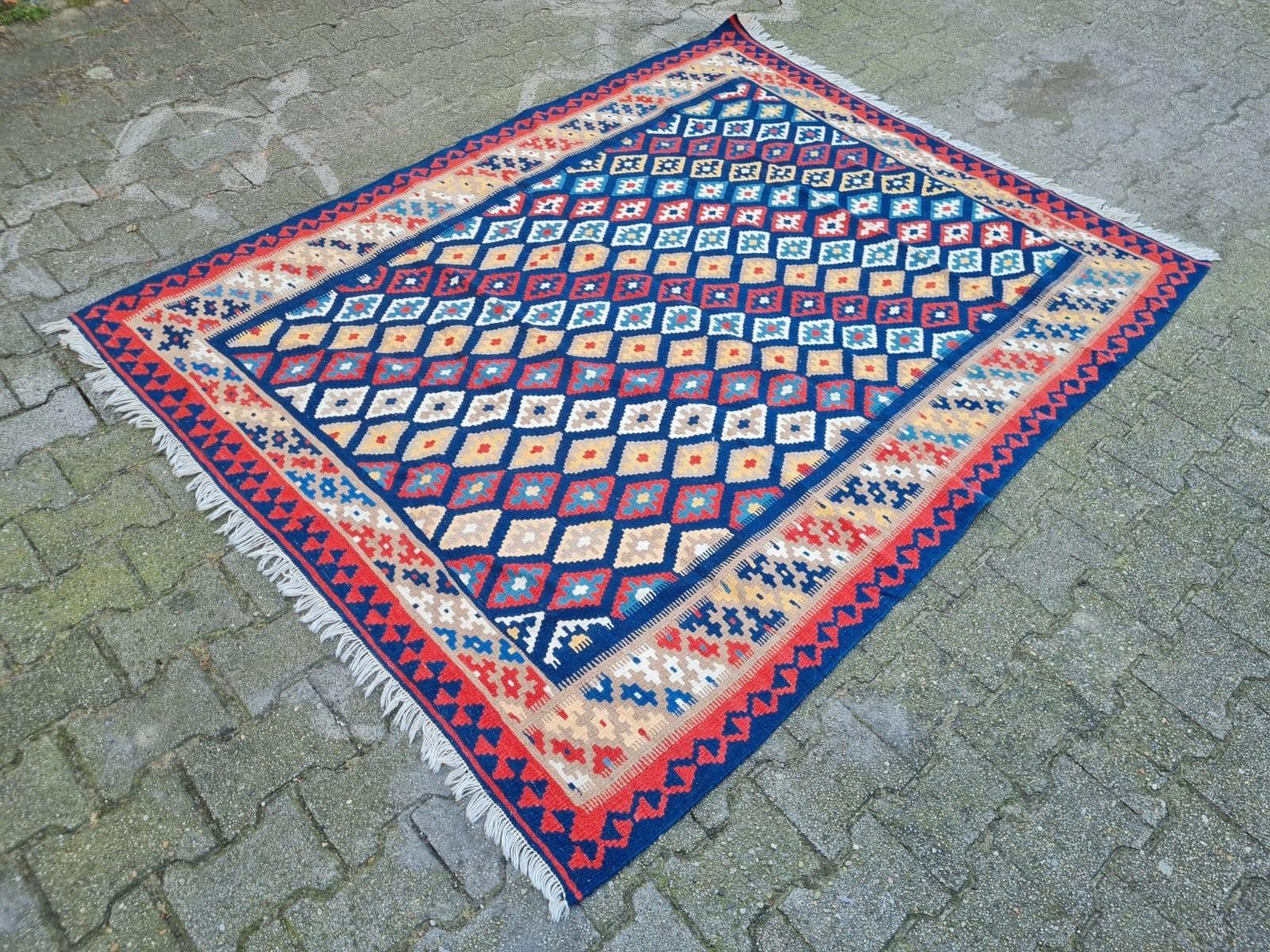 Embrace the Spirit of Nomadic Artistry: Vintage Gashkai Kilim
Discover the vibrant charm of this authentic handmade vintage Persian Gashkai Kilim, originating from the nomadic tribes of the Fars region in Iran and dating from the 1970s. Unlike pile