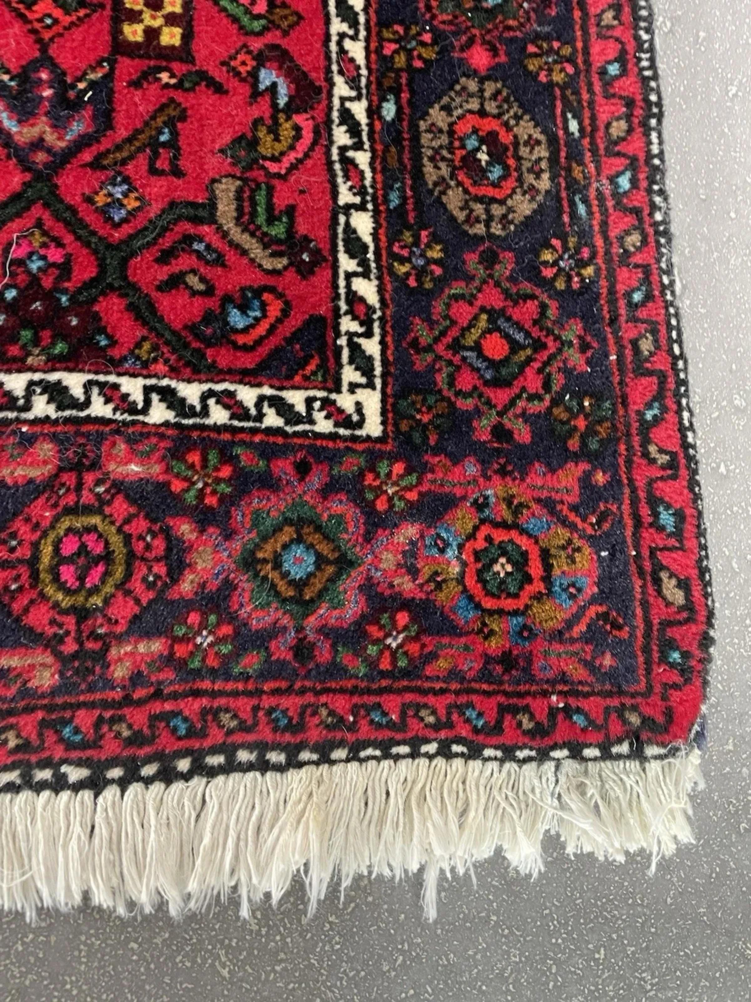 Setzen Sie mit diesem atemberaubenden persischen Hamadan-Teppich im Vintage-Stil einen farbenfrohen Akzent und echte Stammeskunst. Dieser Teppich wurde in den 1950er Jahren aus strapazierfähiger, hochwertiger Wolle handgeknüpft und verkörpert die