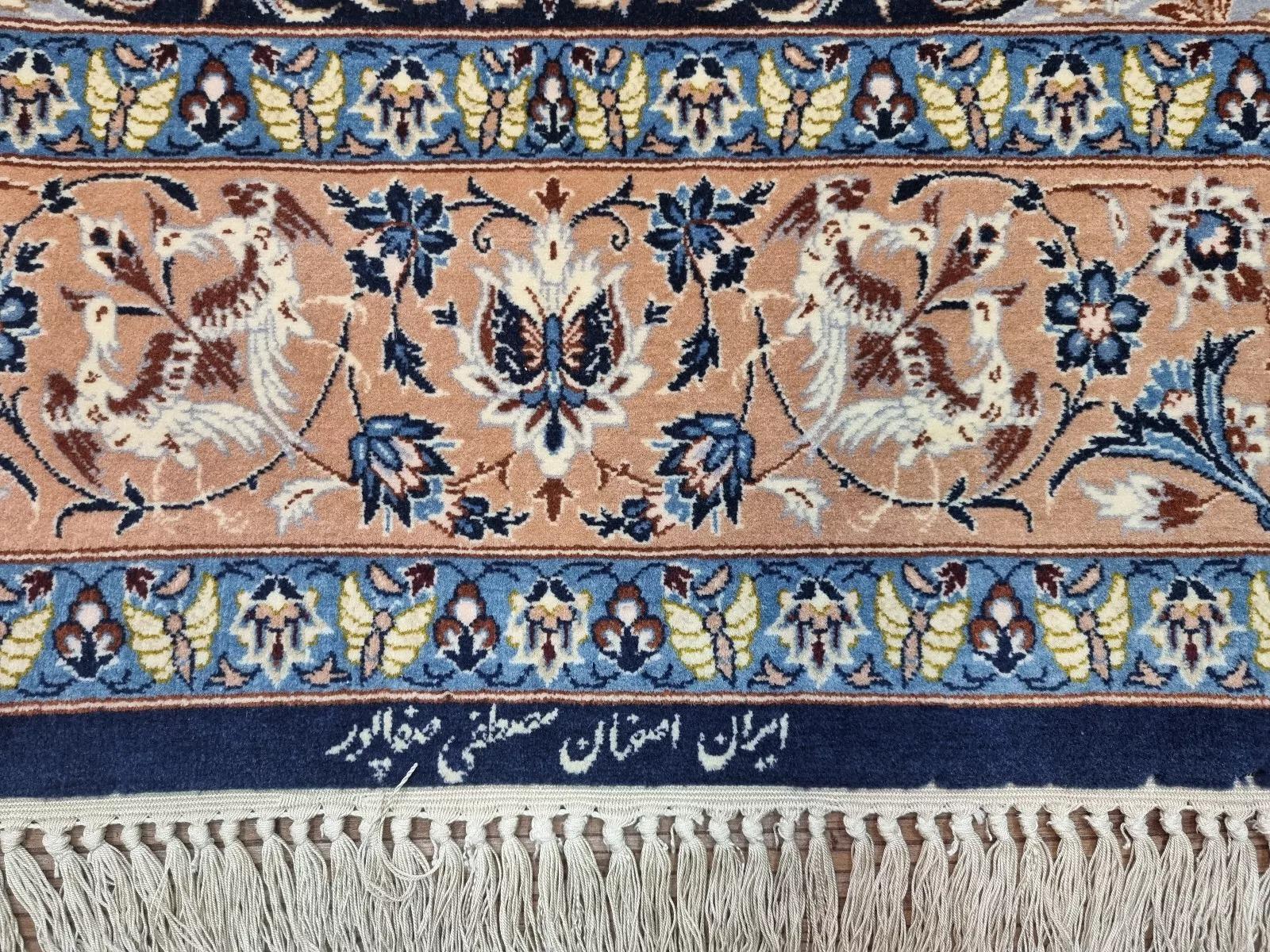 This magnificent Persian Isfahan rug, crafted during the 1970s, is a testament to timeless Persian artistry. Hand-knotted with exceptional skill, it features a luxurious blend of kork wool on a silk foundation, offering a soft yet durable texture.