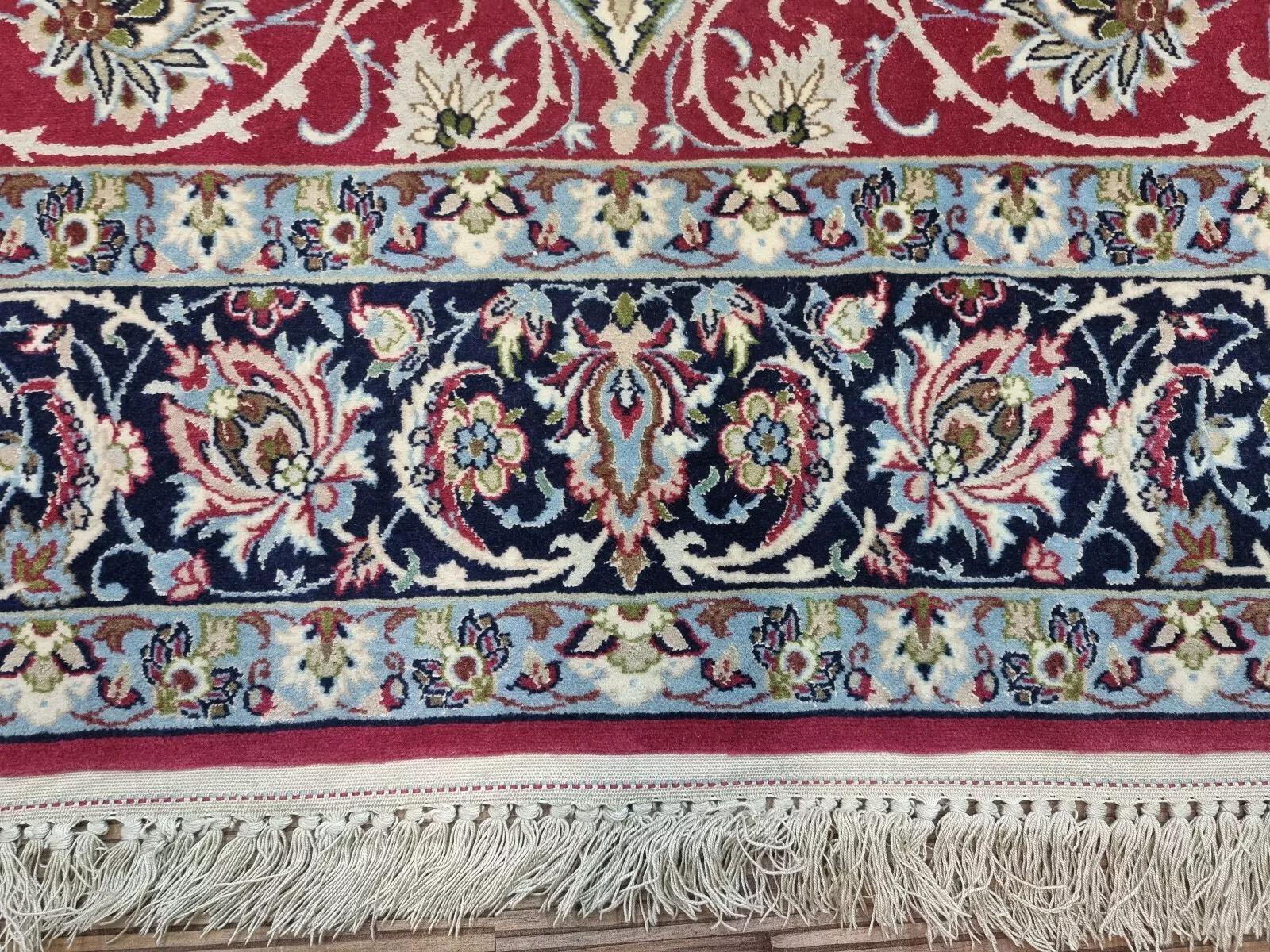Experience the luxury and sophistication of Persian craftsmanship with this stunning Isfahan carpet. Hand-knotted in the 1970s, this exquisite piece features a detailed floral design in rich red tones, crafted from premium Kork wool on a silk