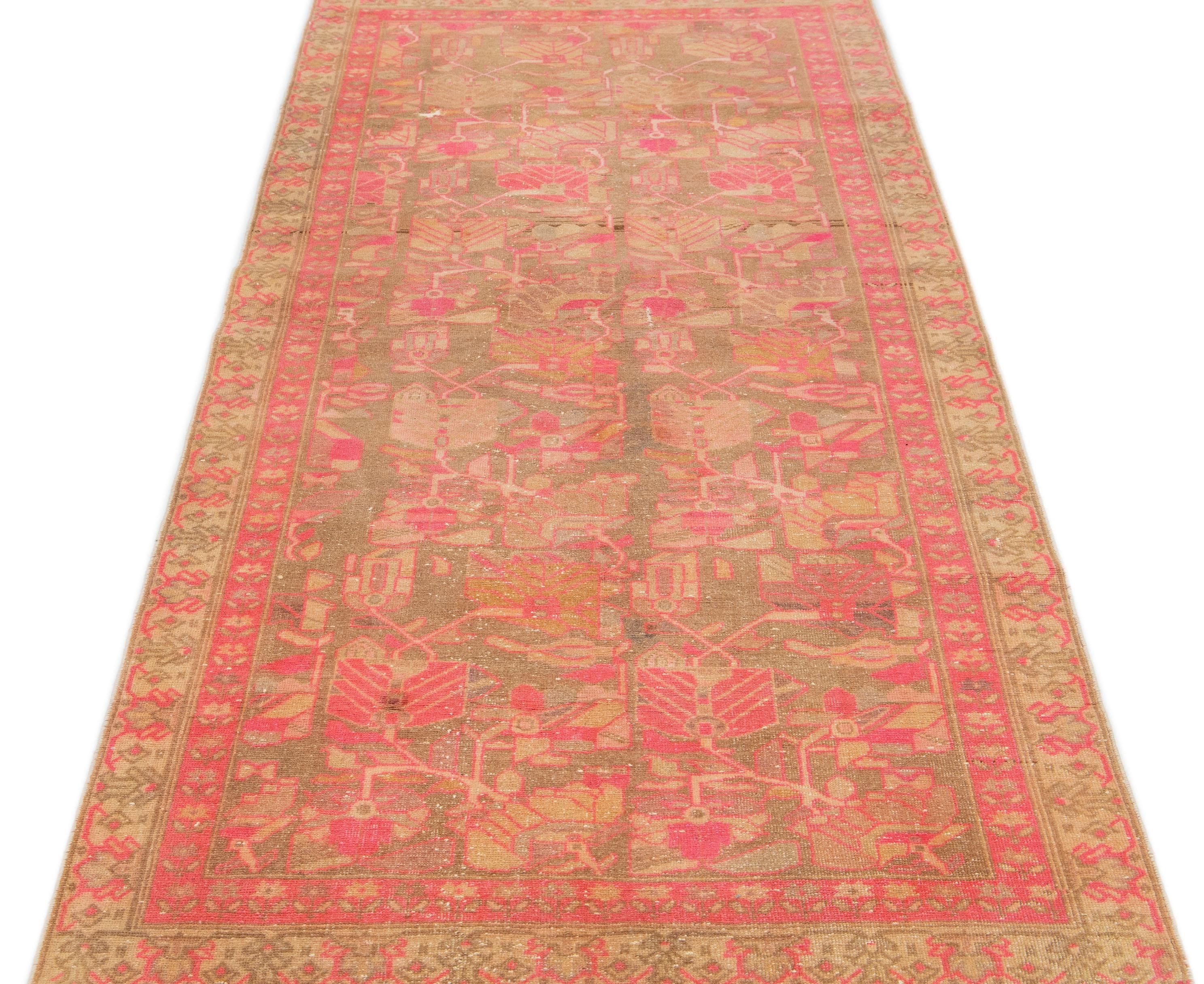 This lovely antique Malayer wool rug is hand-knotted and boasts a charming brown color field. It has a stunning floral pattern design with delightful pink and orange accents.

This rug measures 4' x 9'4