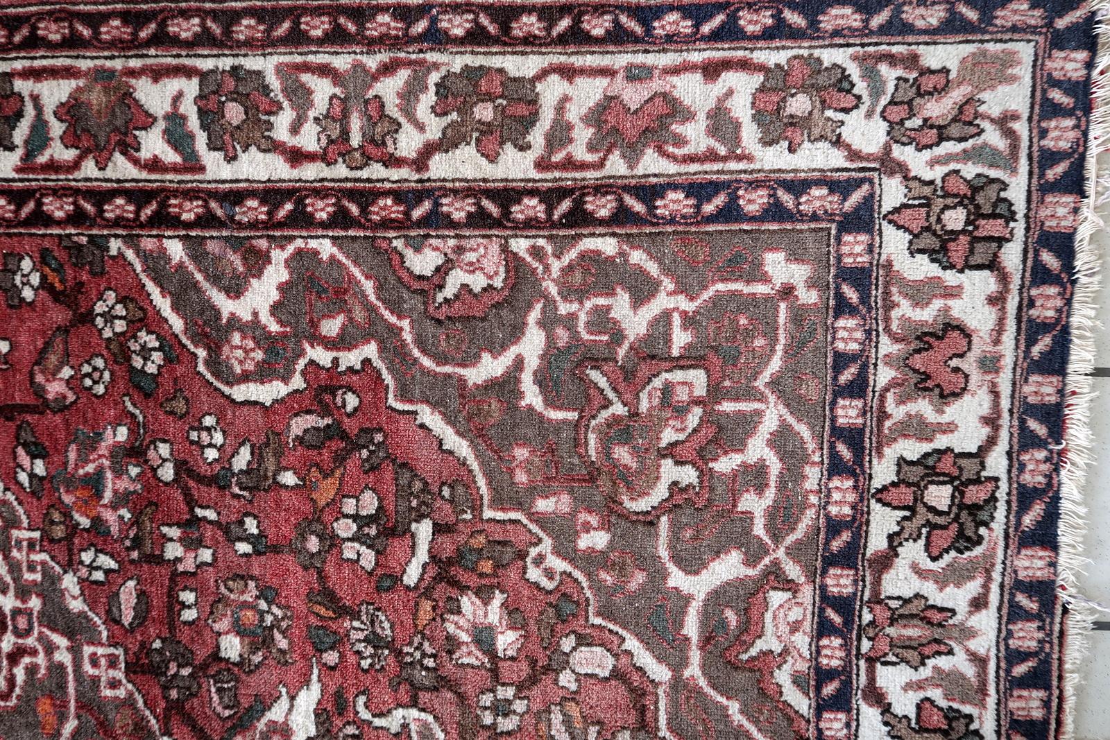 Ce tapis persan vintage Malayer, fait à la main et datant des années 1960, est un exemple stupéfiant de l'artisanat traditionnel. Mesurant 4,7 pieds (144 cm) de largeur et 6,5 pieds (197 cm) de longueur, ce tapis en laine est en bon état et présente