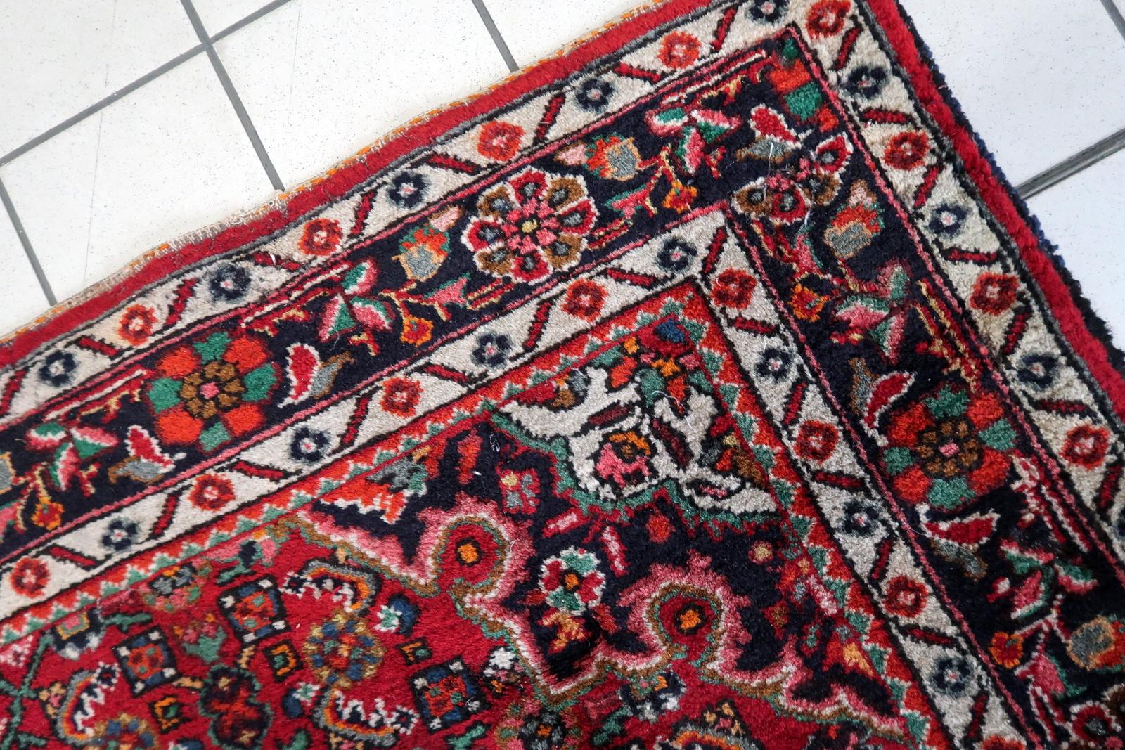 Immerse your home in timeless beauty with our Handmade Vintage Persian Malayer Rug, a captivating piece from the 1960s. Measuring at 5.4' x 7.1', this rug features a traditional floral design in a striking red color, complemented by a small