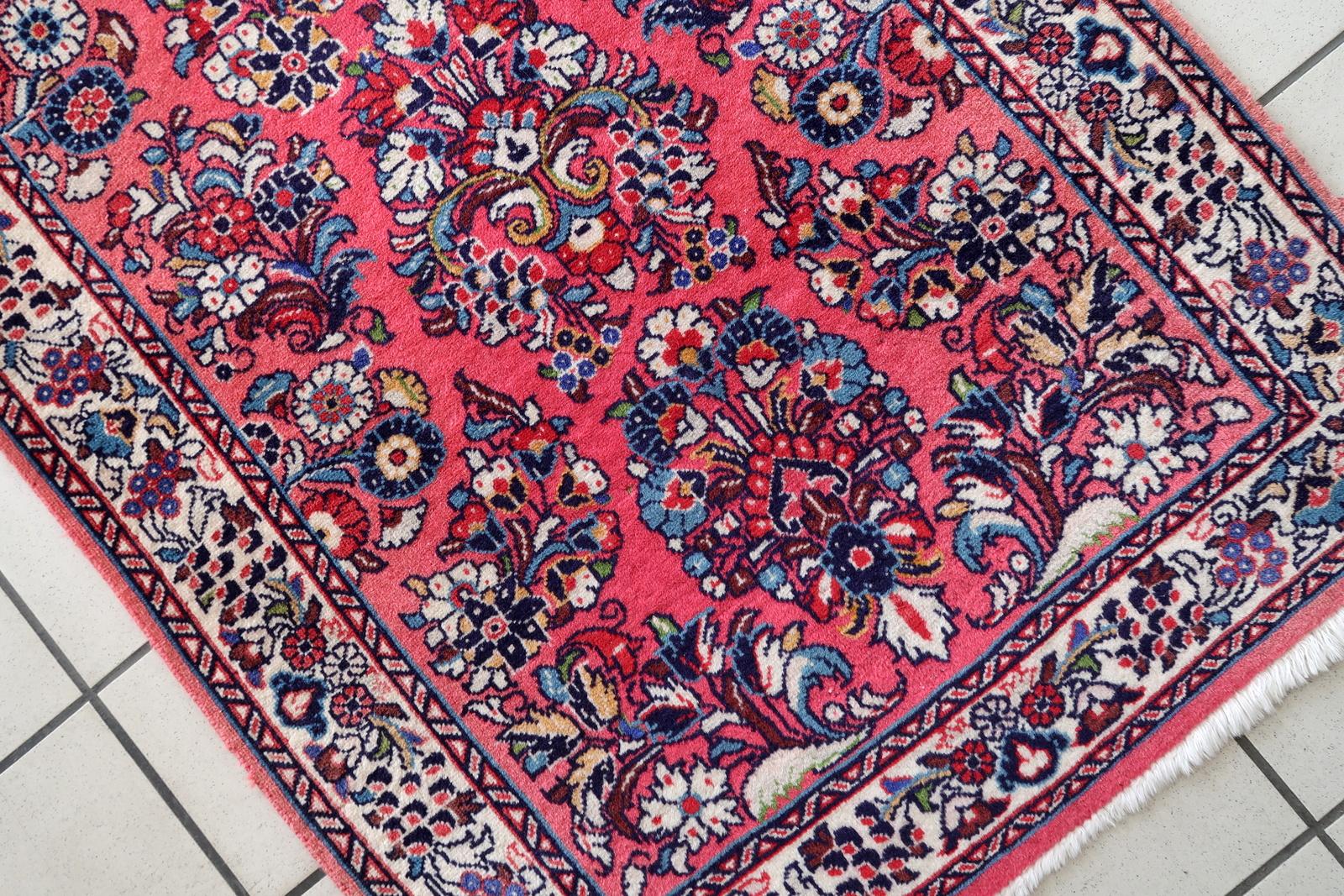 Verschönern Sie Ihr Zuhause mit diesem handgefertigten Sarouk-Läufer aus persischem Vintage-Material. Dieser in den 1960er Jahren gefertigte Teppich misst 2,6' x 6,8' (81cm x 208cm) und ist in gutem, verblasstem Zustand. Das aus hochwertiger Wolle