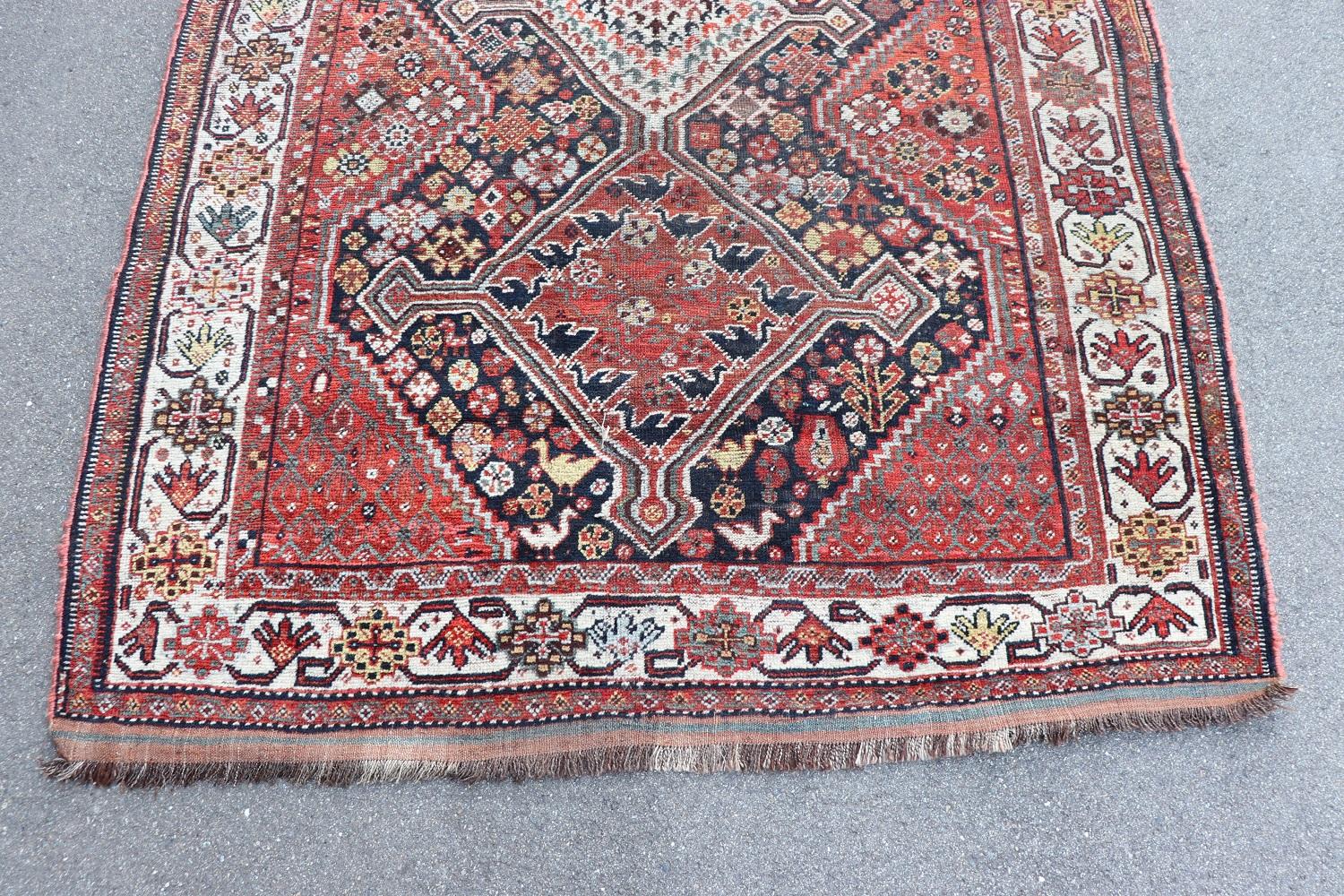 Beautiful 20th century ( 1950s circa)  persian shiraz rug handmade in wool and cotton warp. This fantastic rug it is in the main color red with a motif of central medallions with figures of birds. Used conditions.
   
