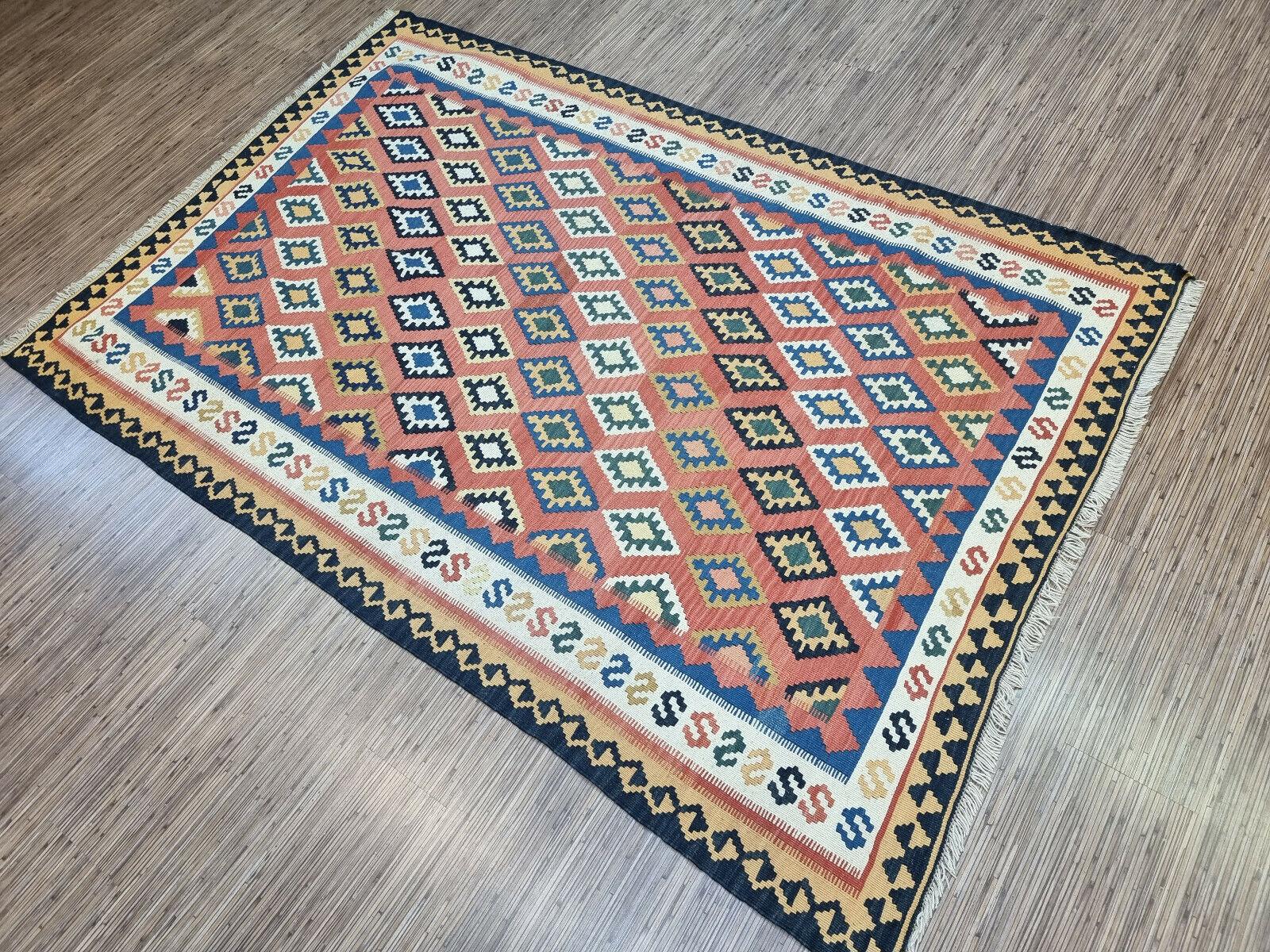 Add a splash of color and charm to your space with this Handmade Vintage Persian Style Ardabil Kilim Rug. This flatweave wool rug, measuring 4.9’ x 7.2’, is a stunning piece of art that showcases the intricate craftsmanship and rich cultural