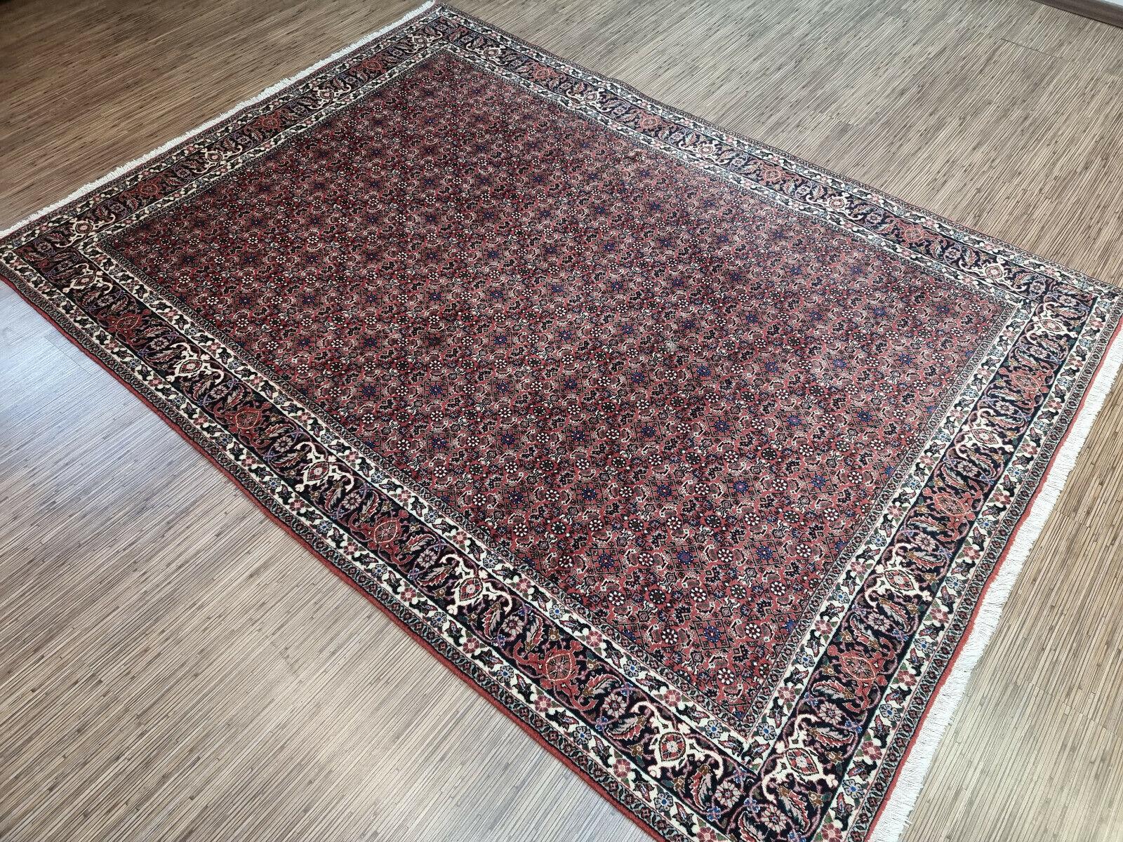 Transform your space with our Handmade Vintage Persian Style Bidjar Rug. This stunning rug is a masterpiece of craftsmanship and design, dating back to the 1970s. It measures 5.7’ x 7.8’, making it ideal for large spaces or as a centerpiece.

The