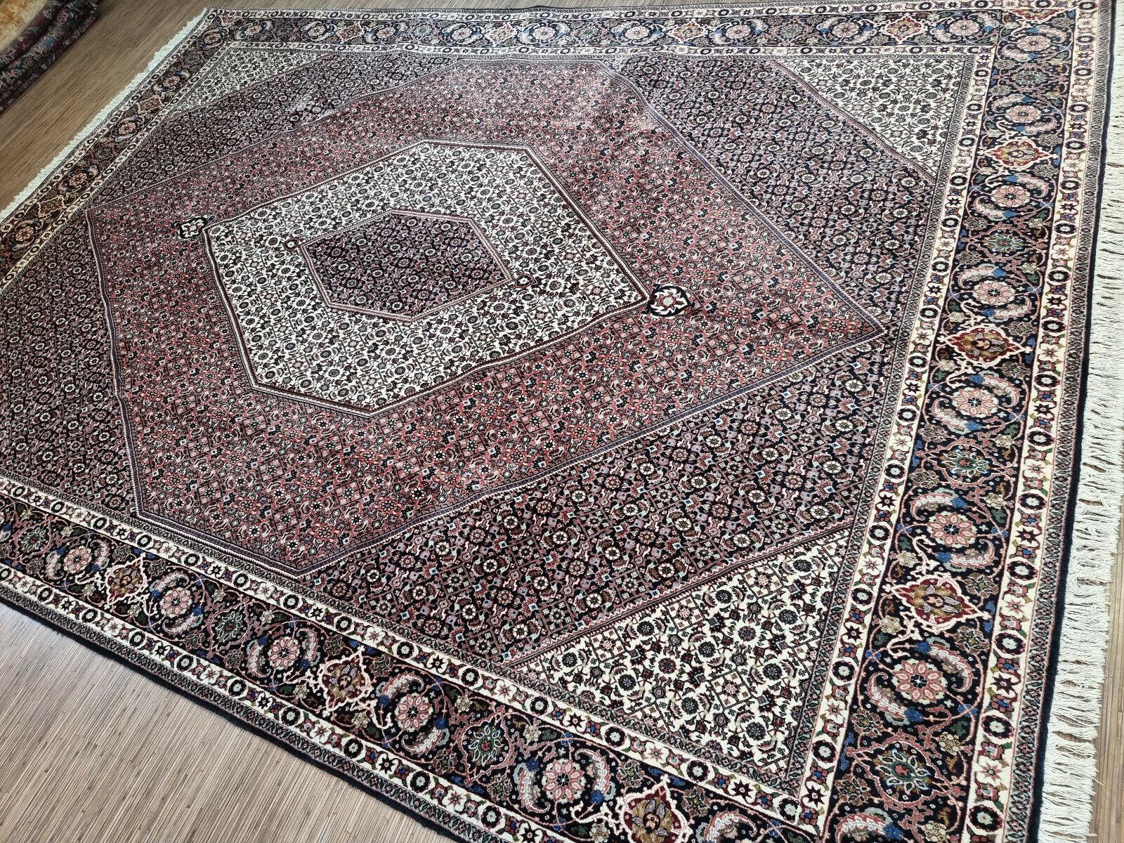 Wenn Sie auf der Suche nach einem Teppich sind, der Ihrem Wohnraum einen Hauch von Vintage-Eleganz verleiht, ist dieser handgefertigte Bidjar-Teppich im persischen Vintage-Stil genau das Richtige für Sie. Dieses atemberaubende Kunstwerk zeigt die