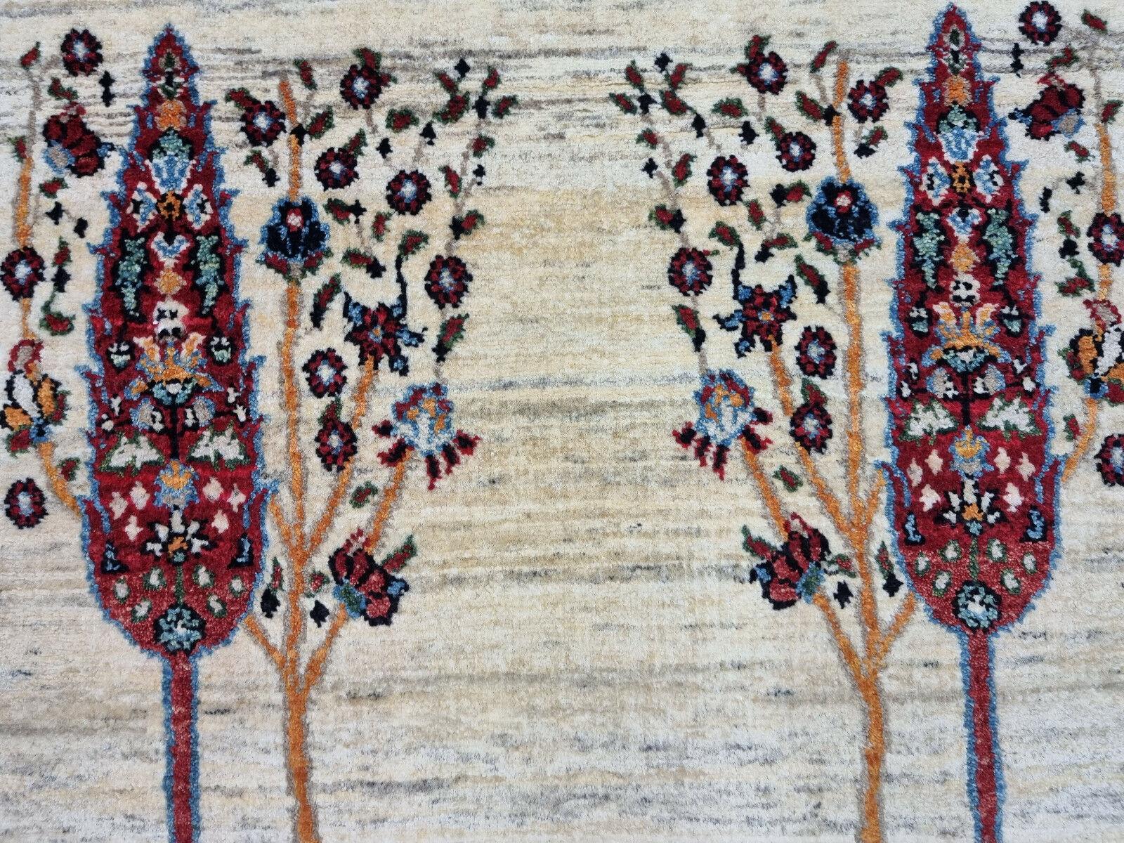 Design/One: Questo tappeto fatto a mano presenta una rappresentazione artistica di alberi e motivi di fogliame. Il design emana un fascino vintage.
Colori:
Base: Il colore dello sfondo è un beige sbiadito che contribuisce al suo aspetto