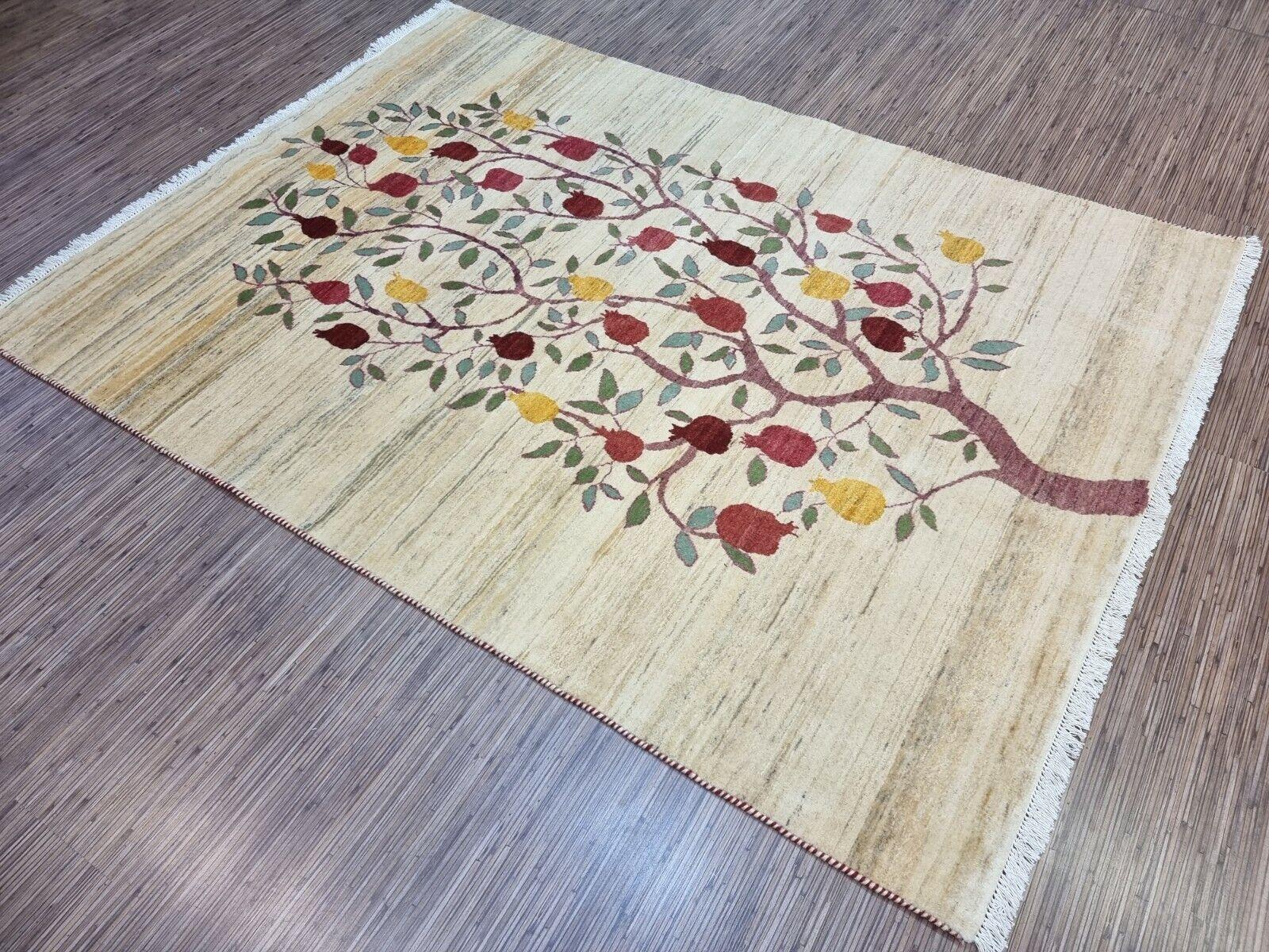 Bring home a piece of history and art with this Handmade Vintage Persian Style Gabbeh Rug. This stunning rug from the 1970s is in good condition, featuring a unique and intricate design of a fruit-bearing tree.

The rug has a cream-colored