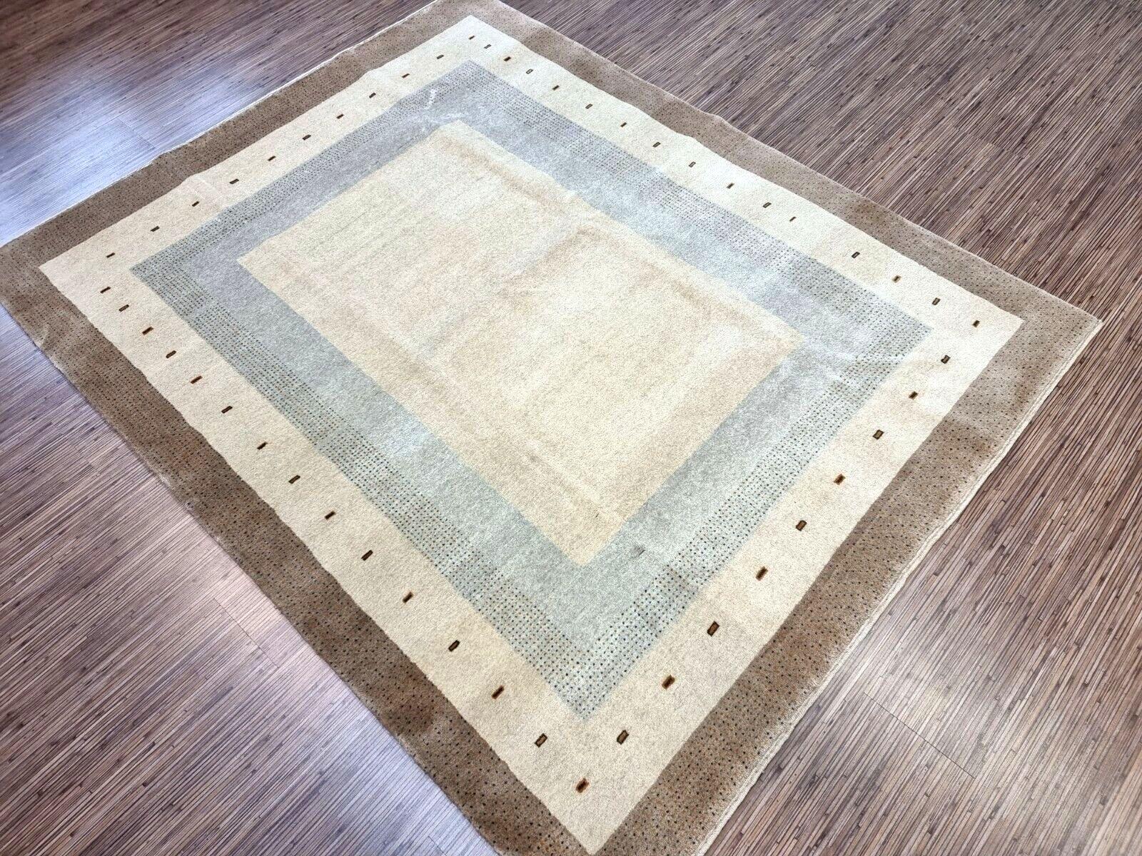 Design and Patterns:

This rug embodies the essence of traditional Gabbeh rugs, known for their thick pile and earthy color palette.
The base color is a soothing beige, creating a neutral canvas.
Geometric patterns and symbols are subtly woven into