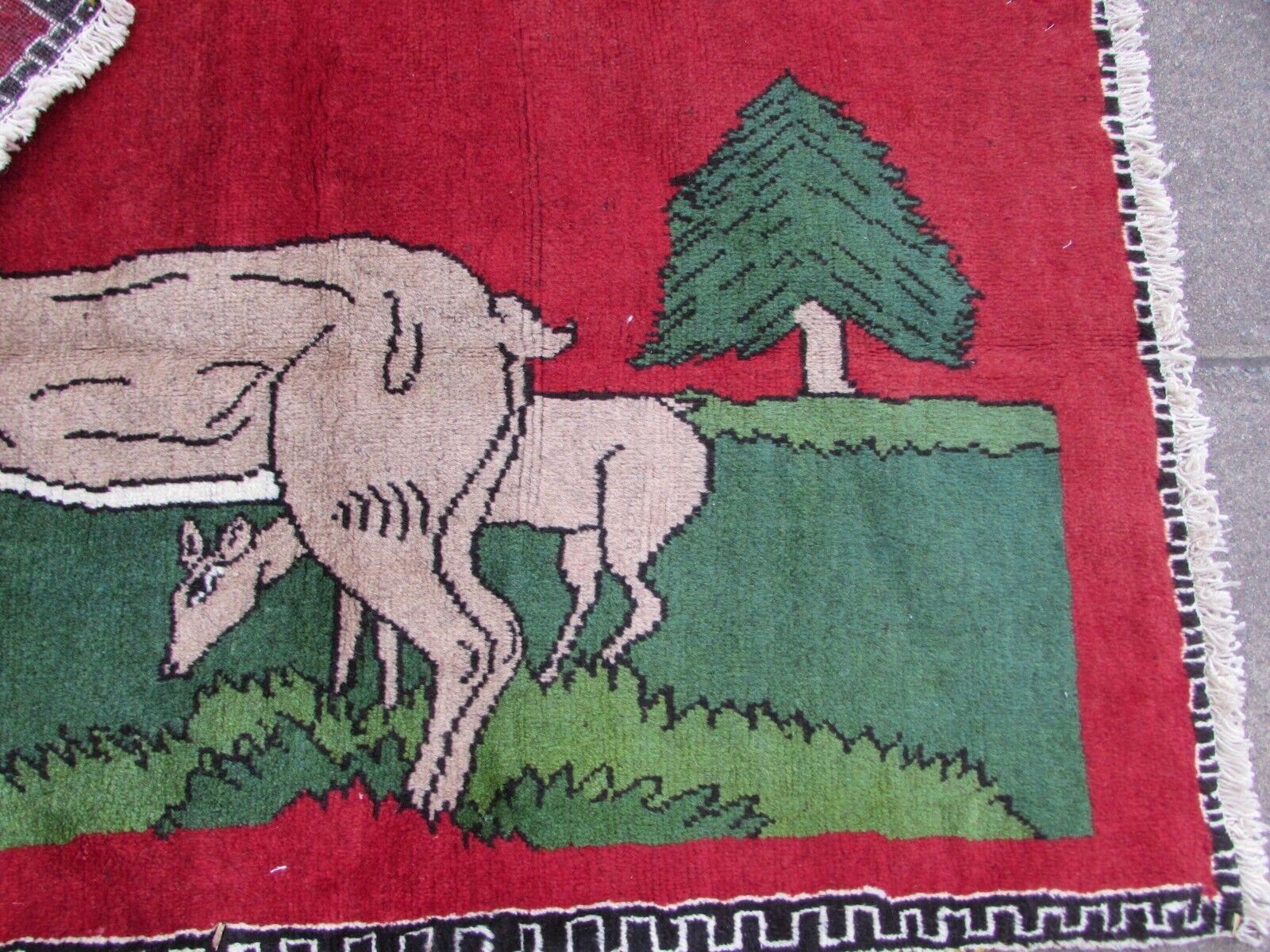 Introduce a touch of rustic charm and elegance to your living space with this Handmade Vintage Persian Style Gabbeh Rug featuring a captivating image of a deer. Crafted in the 1970s, this rug is a unique and artistic addition to your home