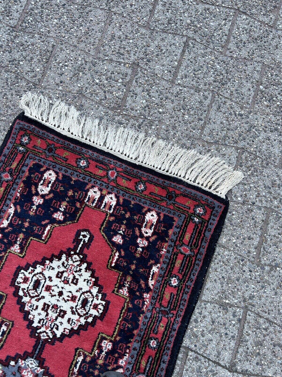  Holen Sie sich mit diesem handgefertigten Hamadan-Teppich im persischen Vintage-Stil ein Stück persisches Erbe in Ihr Zuhause. Dieser in den 1970er Jahren gefertigte Teppich misst 2,1' x 4,4' (66cm x 137cm) und ist ein schönes Beispiel für die