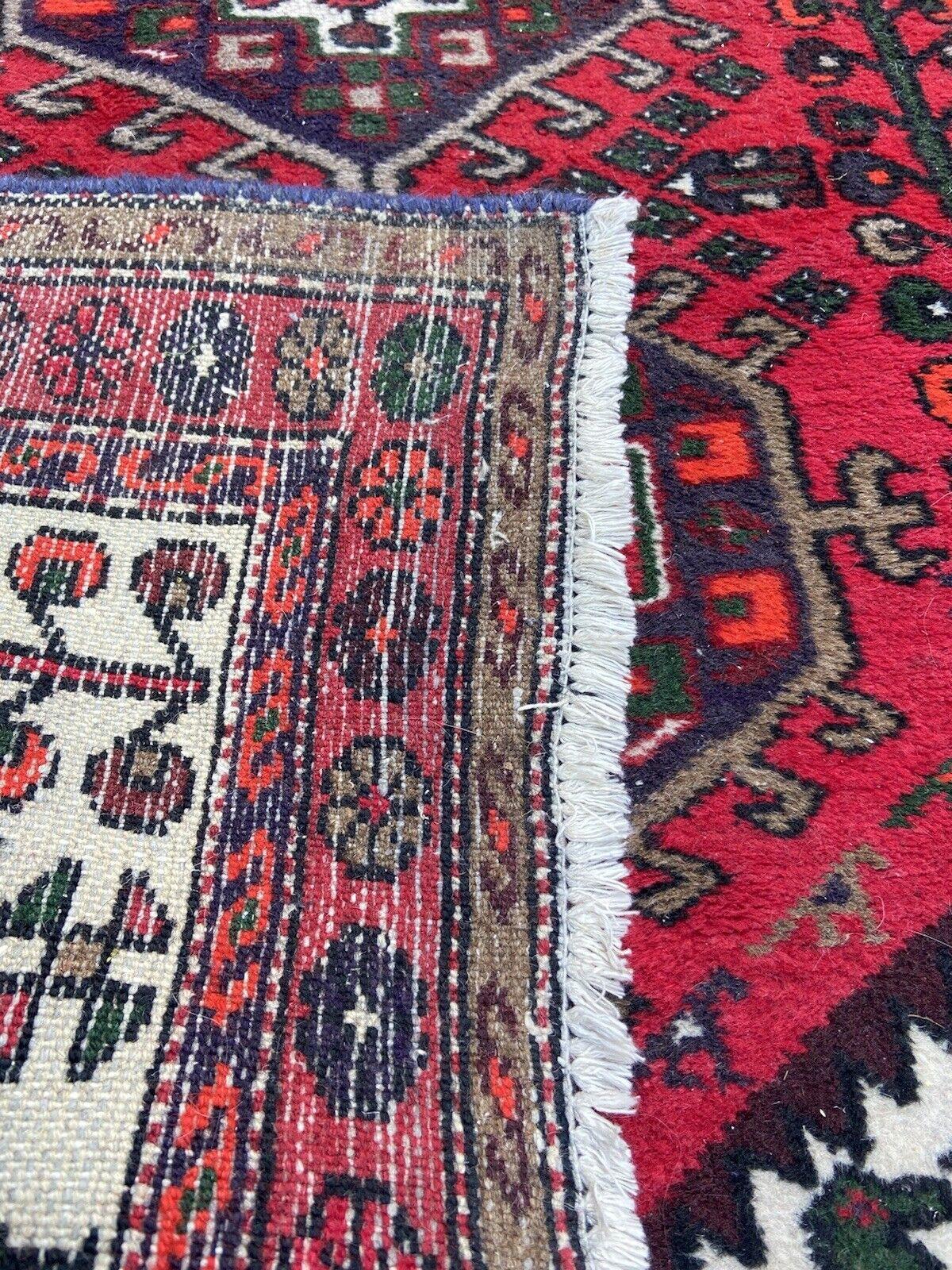 Introducing our Handmade Vintage Persian Style Hamadan Rug, a timeless piece dating back to the 1960s. Measuring at 3.3' x 4.8', this rug boasts a rich history and unique character that adds a touch of vintage charm to any space.

The vibrant color