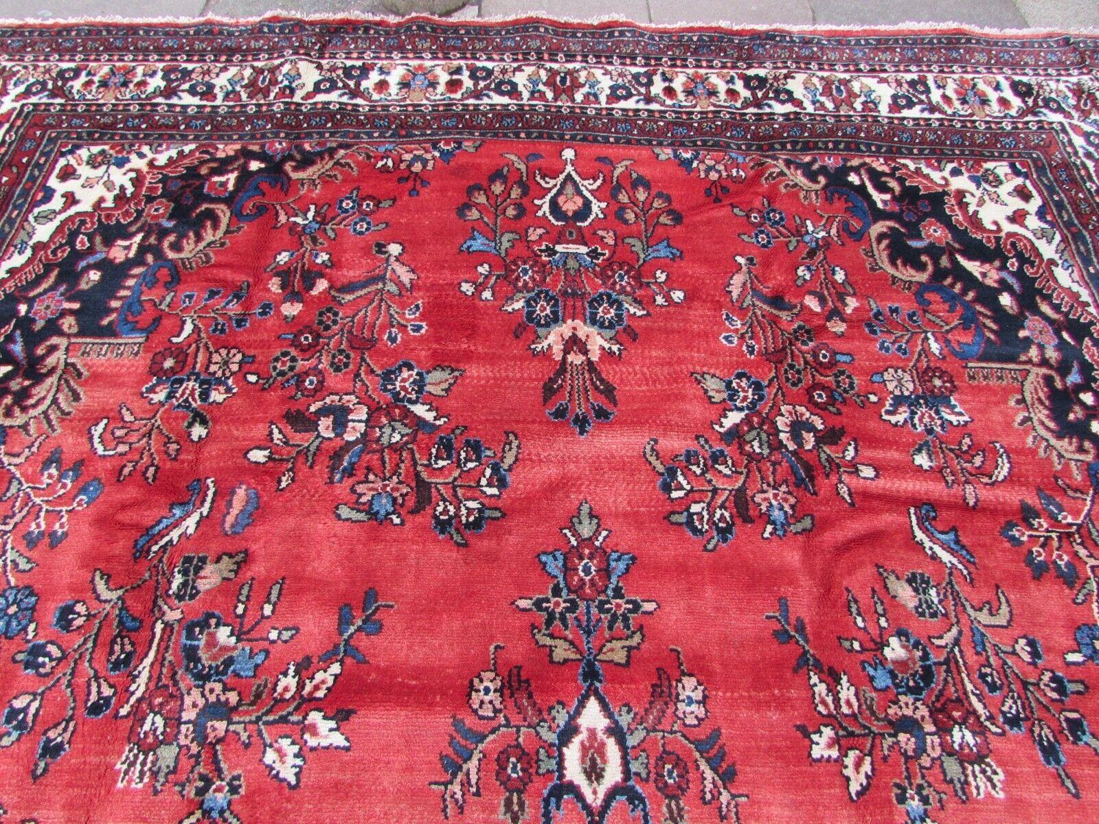 Elevate your living space with the charm and elegance of this Handmade Vintage Persian Style Malayer Oversize Rug. Created with care in the 1970s, this rug showcases classic Persian design elements that add warmth and character to your