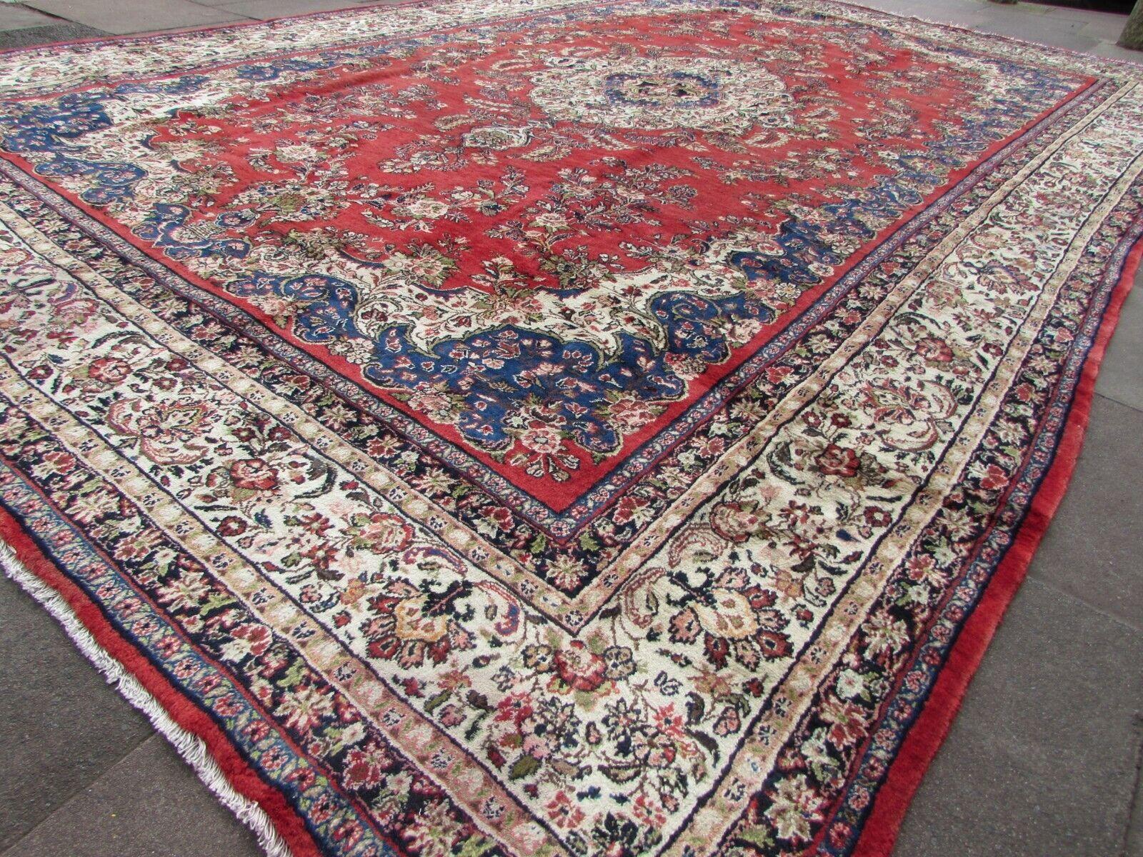 Elevate the grandeur of your living space with this Handmade Vintage Persian Style Sarouk Red Rug, a true masterpiece that exudes opulence and elegance. Crafted in the 1970s, this oversize, palace-size rug in striking red color and good condition is