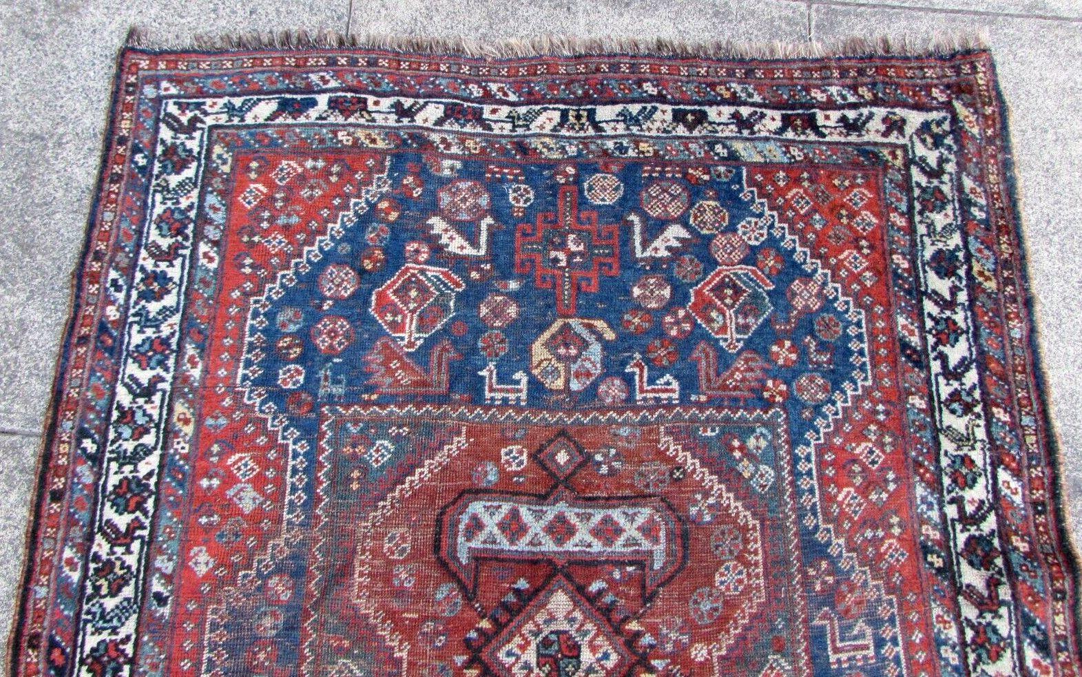 This is a stunning antique antique Persian Shiraz rug, handmade with wool material in the 1920s. It measures 3.8 feet by 4.9 feet (117cm x 150cm) and features a traditional Shiraz style with a beautiful decorative birds design. The background colors