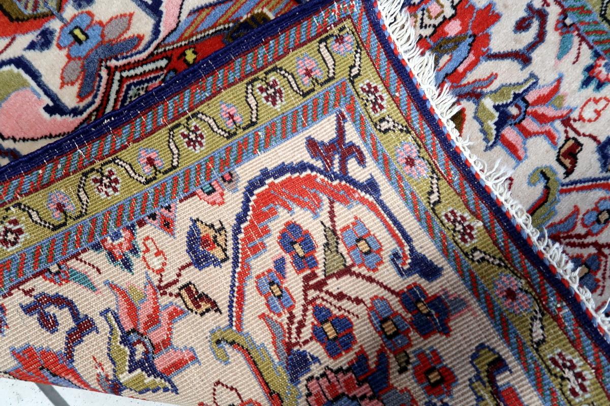 Questo tappeto persiano Tabriz d'epoca fatto a mano, risalente agli anni '50, è uno splendido esempio di arte tradizionale persiana, con un intricato disegno floreale e a medaglioni in tonalità naturali. Perfetto come tappeto d'accento decorativo,