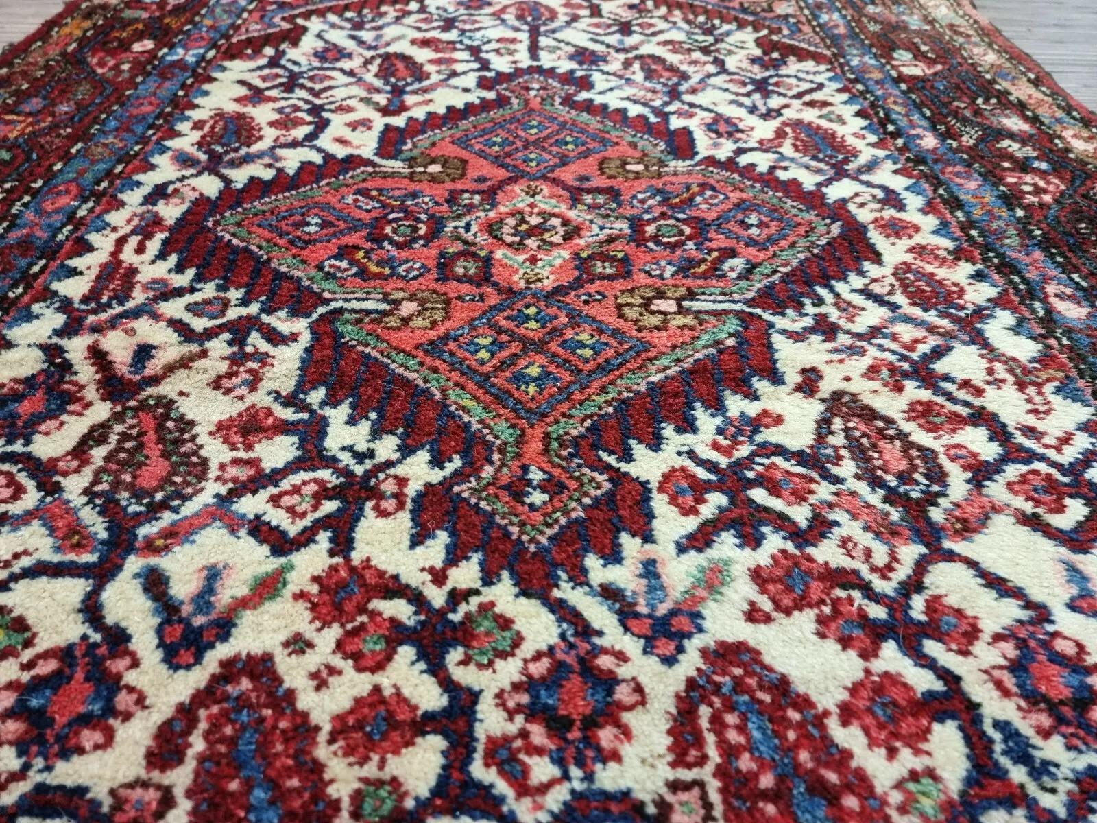 Questo affascinante tappeto persiano vintage Hamadan, realizzato negli anni '50, presenta motivi orientali senza tempo che trasudano eleganza e raffinatezza. Le sue dimensioni compatte e le tonalità calde lo rendono un pezzo d'accento ideale per una