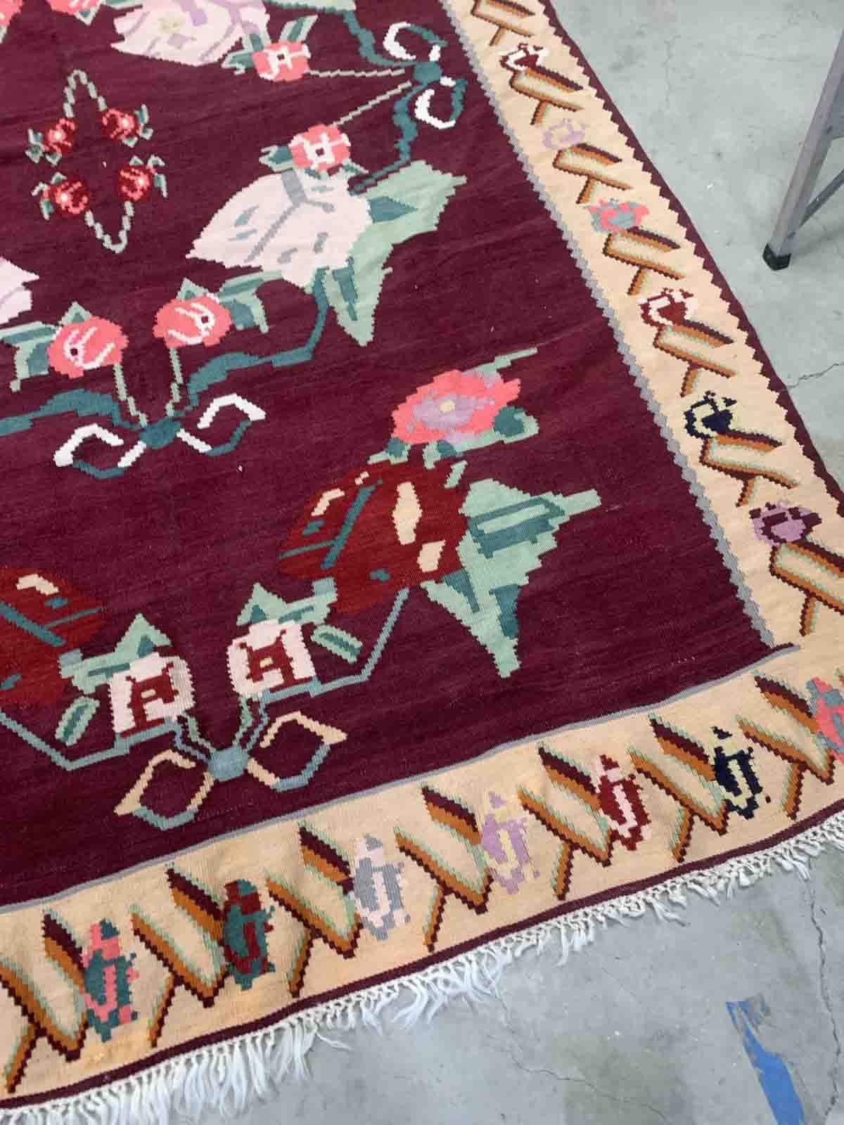 Handmade vintage Bessarabian kilim from Romania and burgundy and beige shades. The rug is from the middle of 20th century in original good condition.

-Condition: original good,

-Circa: 1960s,

-Size: 6.8' x 10' (207cm x 304cm),

-Material: