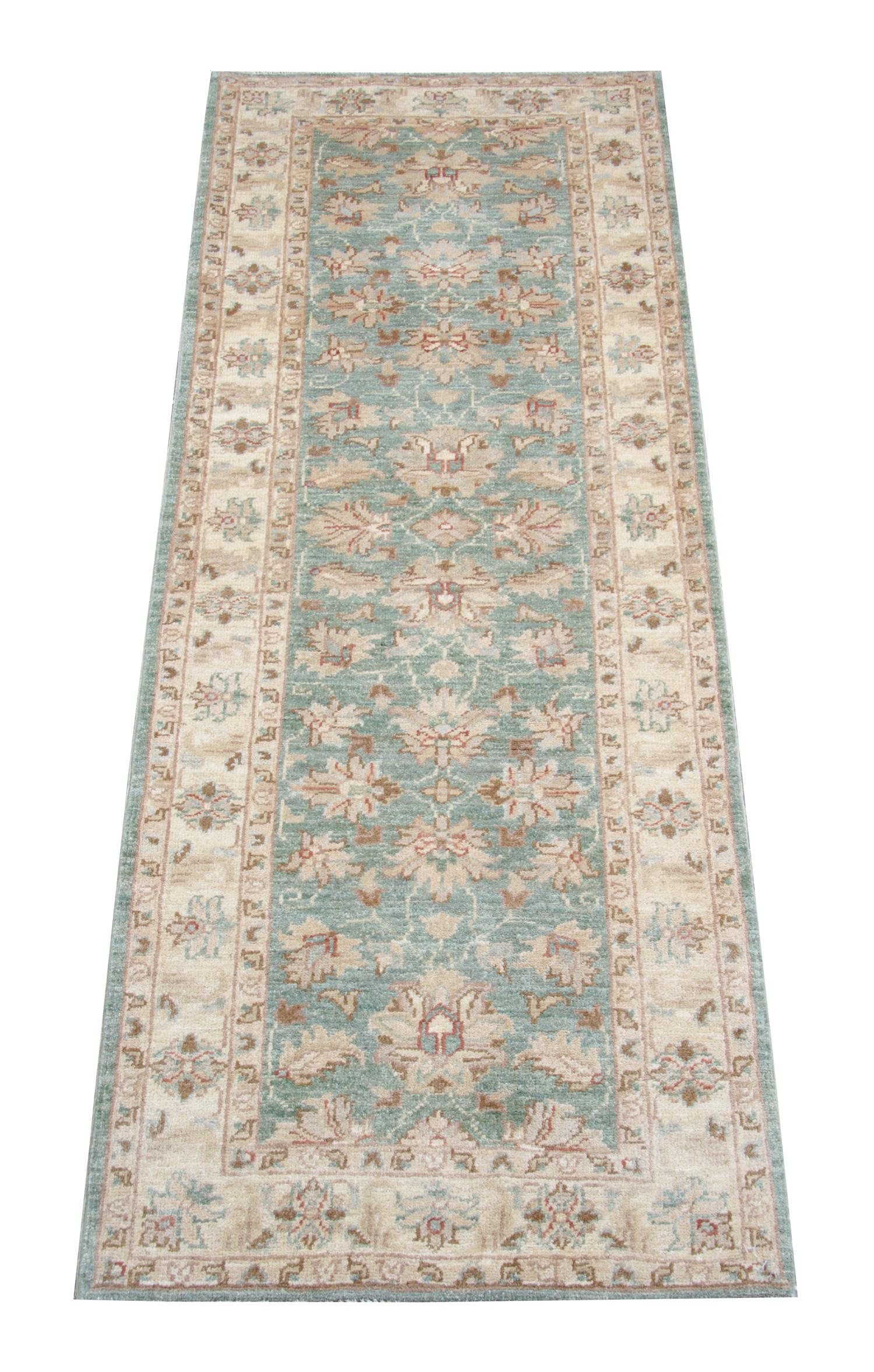 This fine wool Ziegler style runner rug was woven by hand in Pakistan in the late 1990s. The central design features a green background with accents of cream, brown and red accents that make up the symmetrical design. This is then framed by a