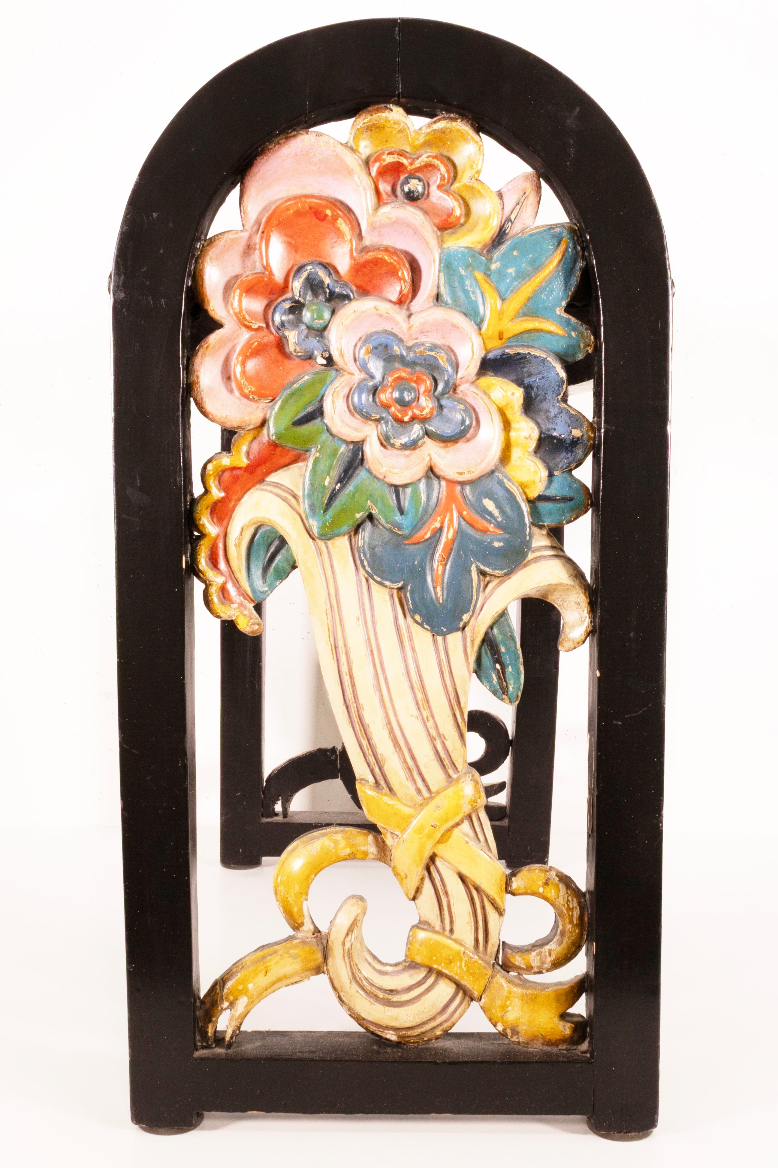 Una panca/sgabello vintage di arte popolare floreale fatta a mano. Questa meravigliosa poltroncina presenta una struttura interamente in legno, con splendidi pannelli laterali intagliati a mano con motivi floreali. Ogni lato è intagliato e dipinto,