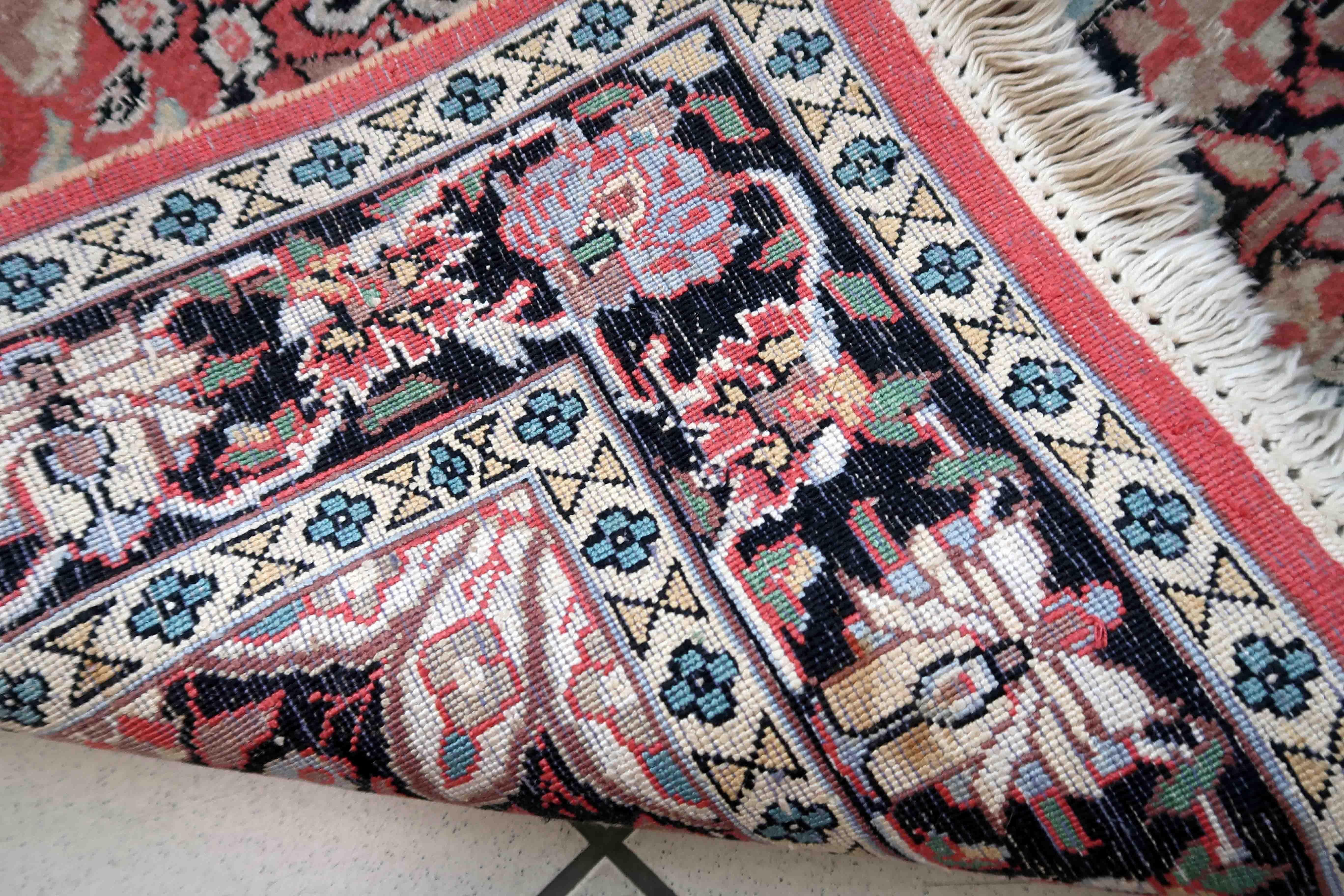 Tapis persan Tabriz vintage fait main en laine du Cachemire. Le tapis est de la fin du 20ème siècle en bon état d'origine. Le tapis présente un motif médaillon traditionnel dans les tons rose et noir. Comme de nombreux Tabriz récents, cet exemple