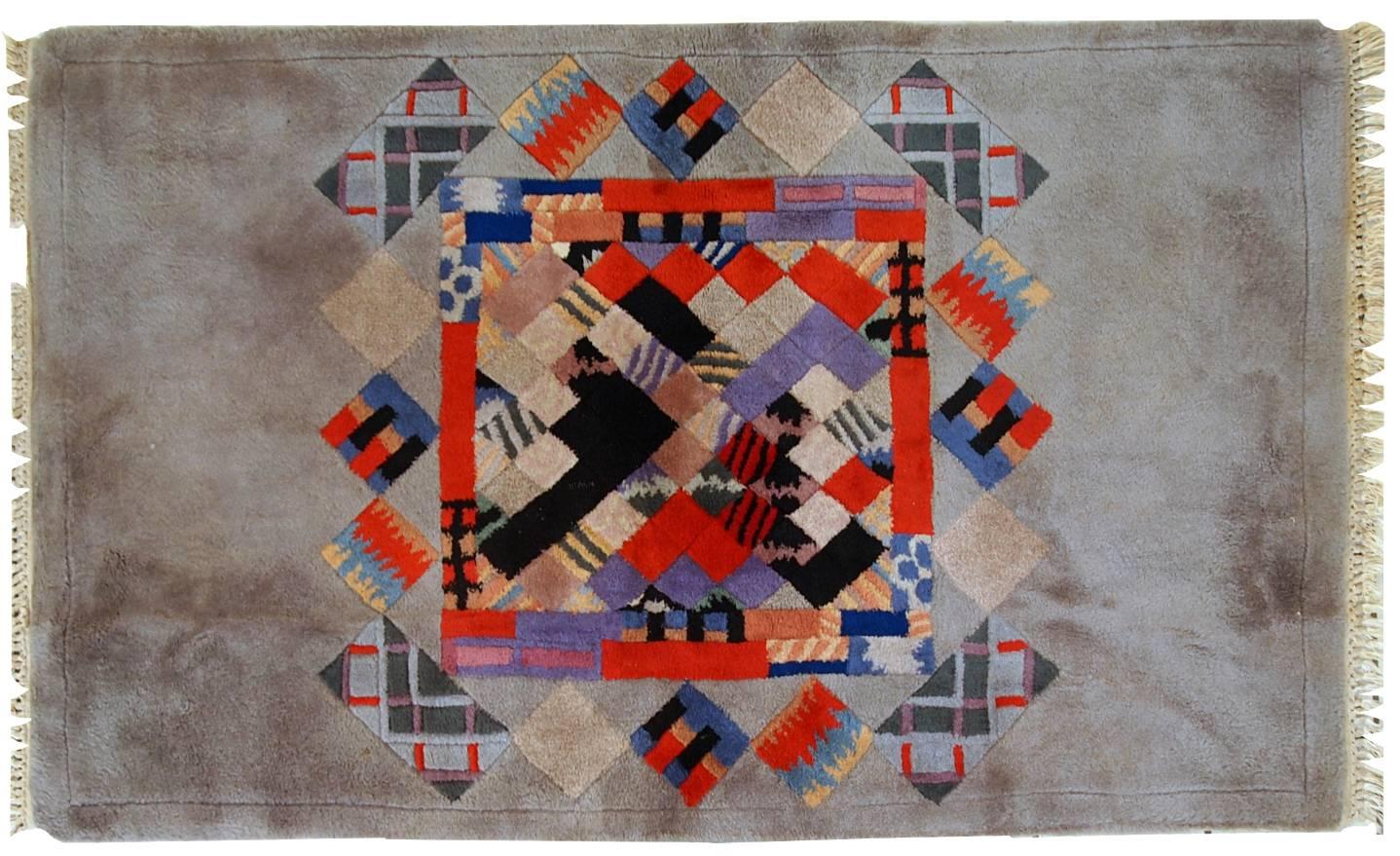 Vintage Tibetan rug with abstract design from Nepal. This masterpiece is from 1980s represents the time of futuristic modernists. Bright shades in the style of Kandinsky on the silver grey background. The rug is handmade and in original good