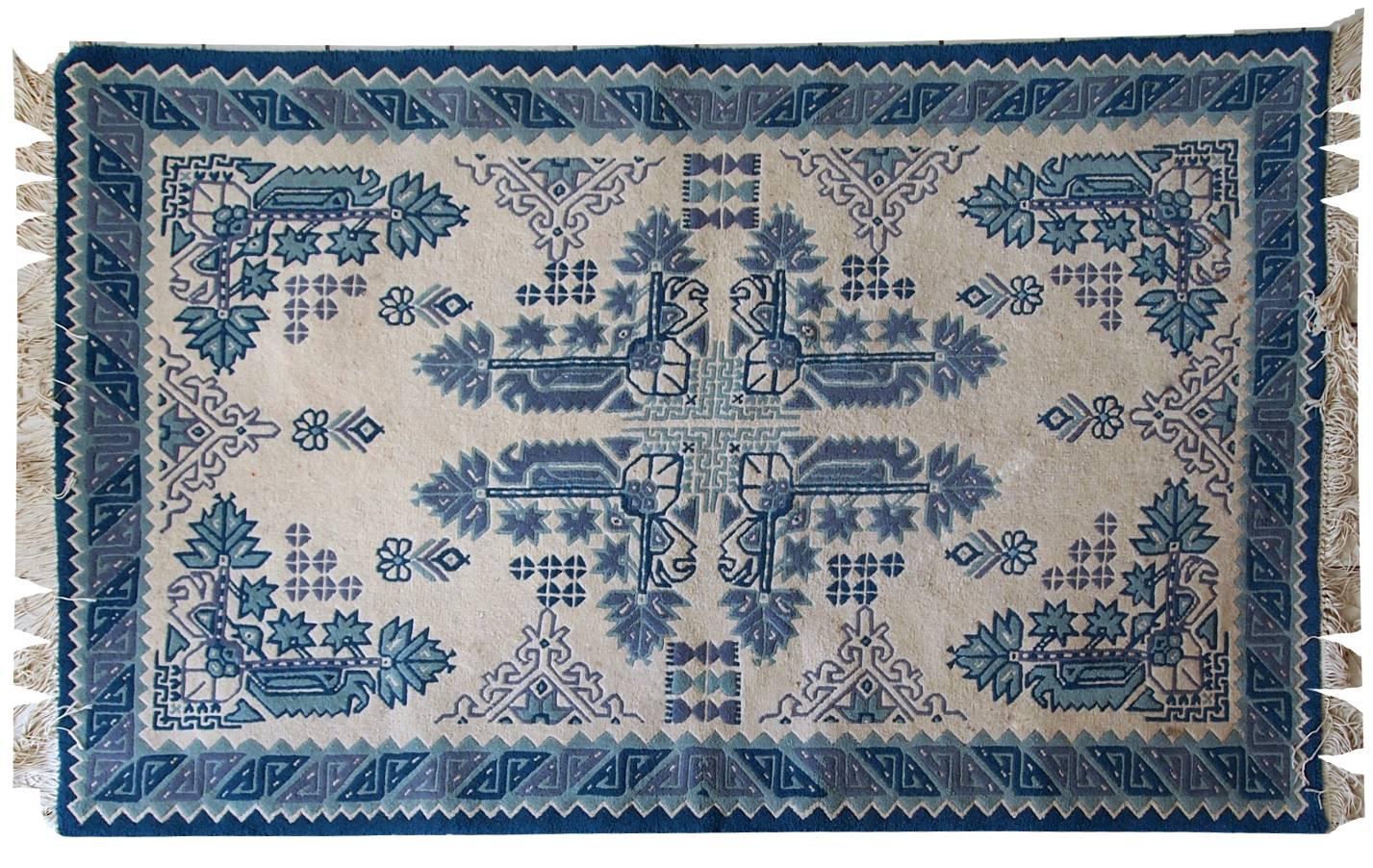 Vieux tapis tunisien fait main dans des tons bleus et blancs. Le tapis est du milieu du 20ème siècle, fait en laine. Il est de conception tribale et en bon état d'origine.
    