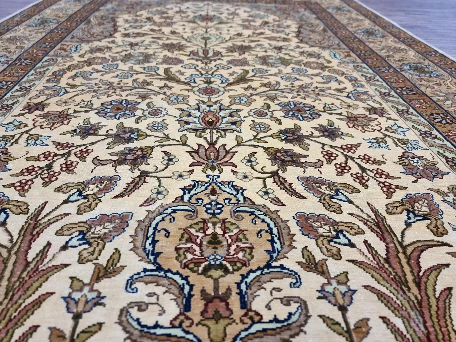 This exquisite vintage Hereke rug is an authentic hand-knotted piece crafted entirely from pure silk, renowned for its luxurious texture and intricate craftsmanship. Signed by the artist, it is a masterpiece that radiates elegance and