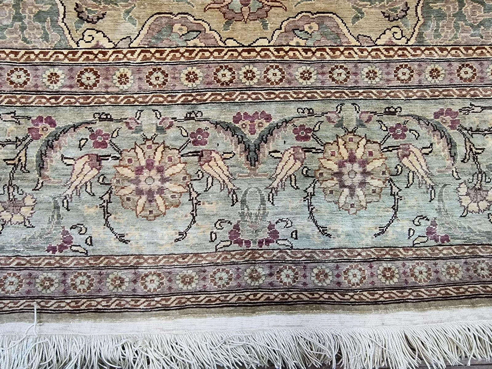 Questo splendido tappeto vintage di Hereke è un pezzo pregiato annodato a mano e realizzato al 100% in pura seta, che testimonia una squisita maestria e un design di lusso. Firmato dall'artista, riflette l'eccezionale qualità associata