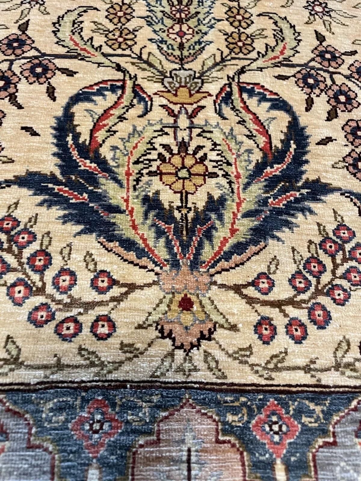 Questo squisito tappeto da preghiera vintage in seta turca Hereke degli anni '70 è un capolavoro senza tempo di artigianato tradizionale. Questo tappeto di seta, che misura 2,26 piedi x 3,31 piedi (69 cm x 101 cm), è in buone condizioni e mostra