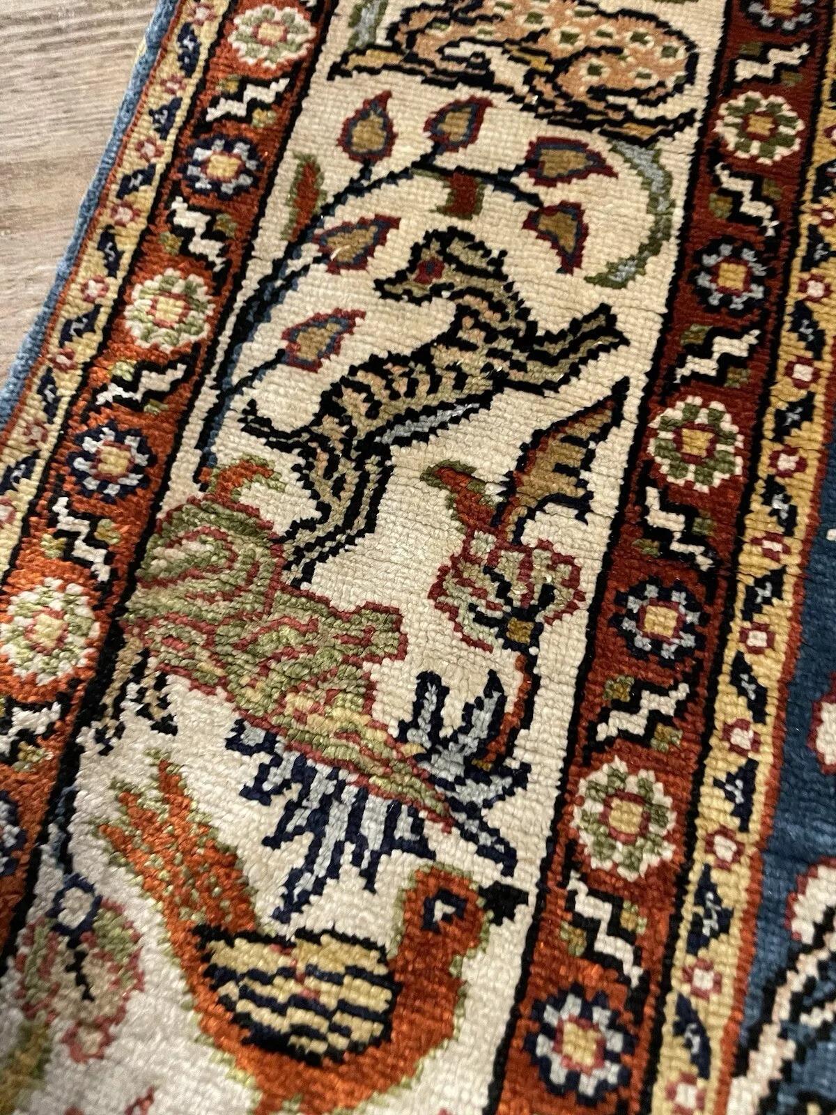 Lasciati conquistare dalla lussuosa maestria di questo tappeto vintage turco Hereke, fatto a mano e risalente agli anni Settanta. Realizzato interamente in seta, questo pezzo eccezionale presenta un'intricata serie di motivi floreali e incantevoli